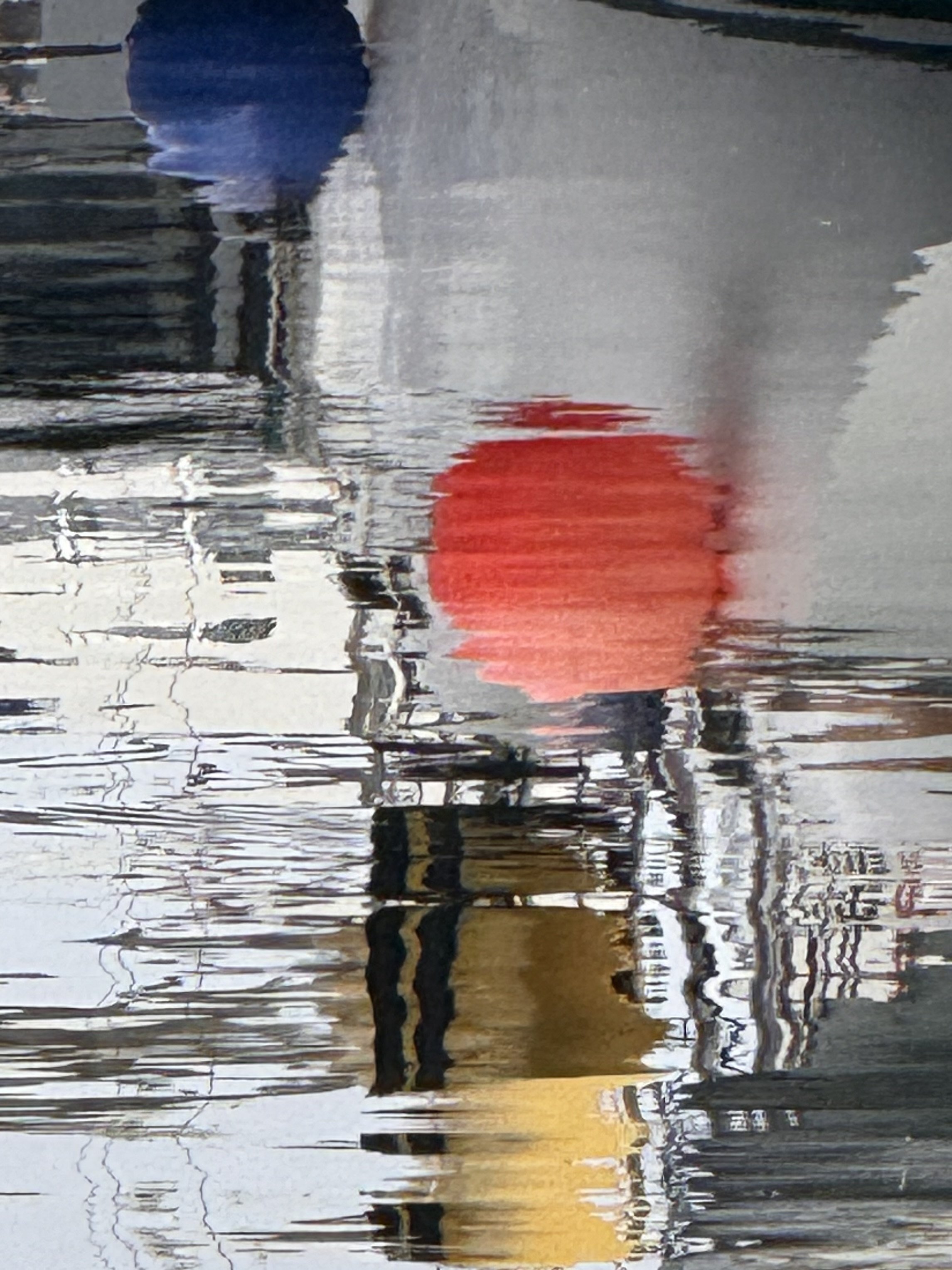 A painting of a city street with buildings, trees, and a person walking a dog, reflected in a puddle of water.