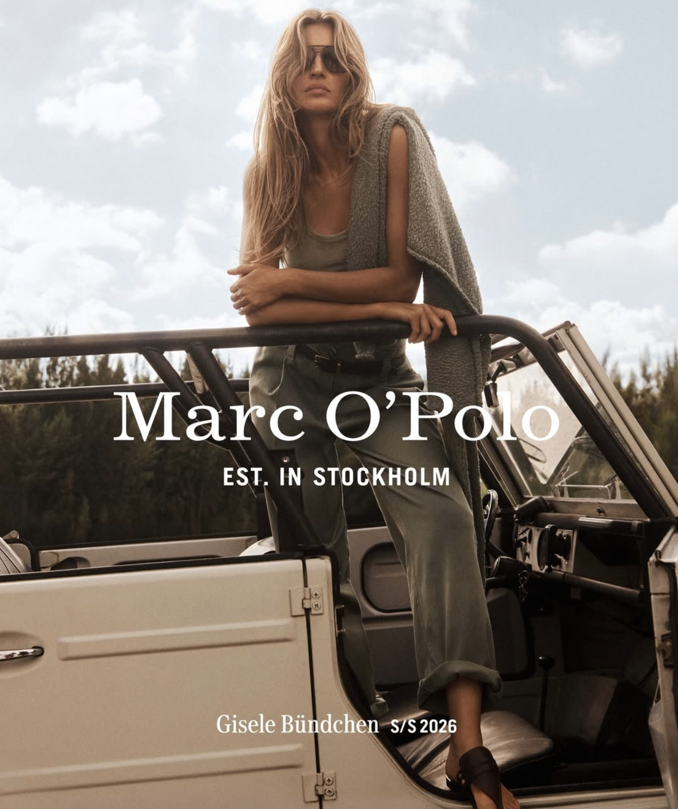 Fashion catalog cover featuring a woman with long hair, sunglasses, and a sleeveless sweater, leaning on a vintage off-road vehicle against a partly cloudy sky. Text reads 'Marc O'Polo, Est. in Stockholm, Gisele Bündchen, S/S 2026'.