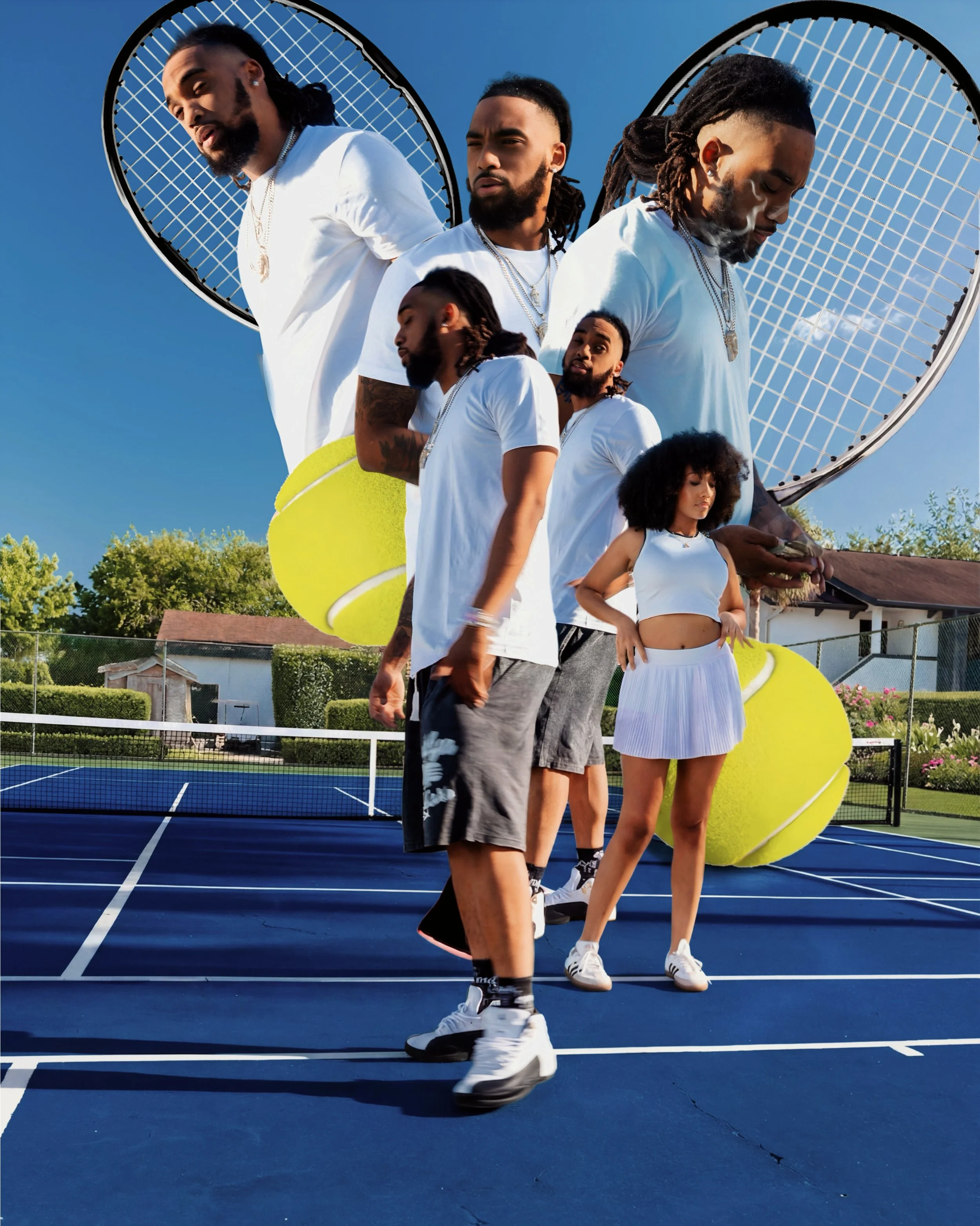 Four people are standing on a blue tennis court, with tennis rackets on their shoulders, against a bright blue sky and trees in the background.