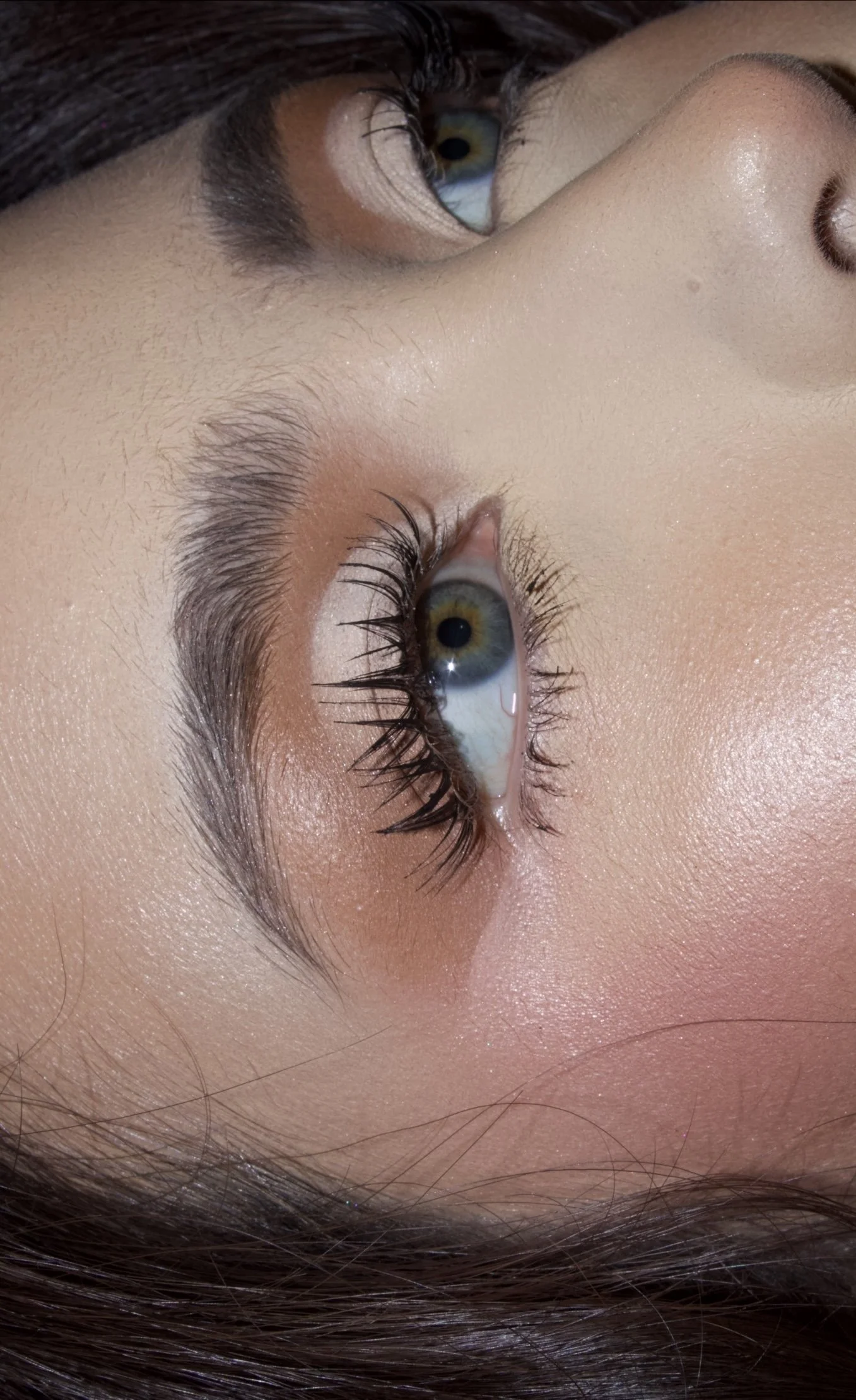 Close-up beauty portrait focusing on detailed eye makeup, featuring defined lashes, polished brows, glowing skin, and soft glam makeup details.