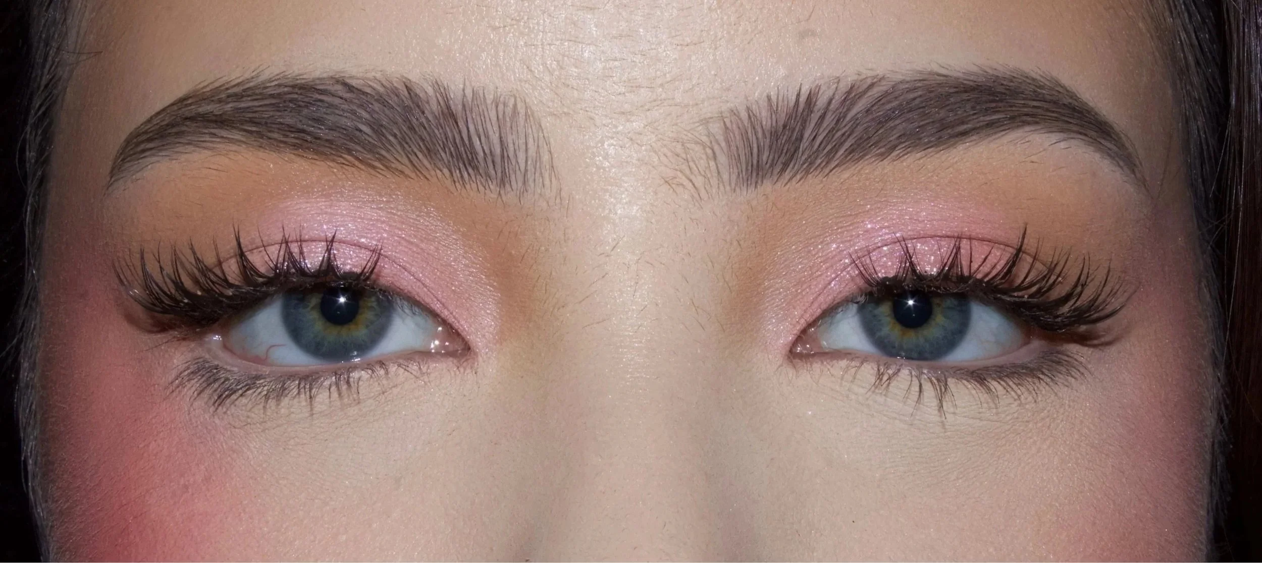 Close-up of a person's eyes with makeup and long eyelashes.
