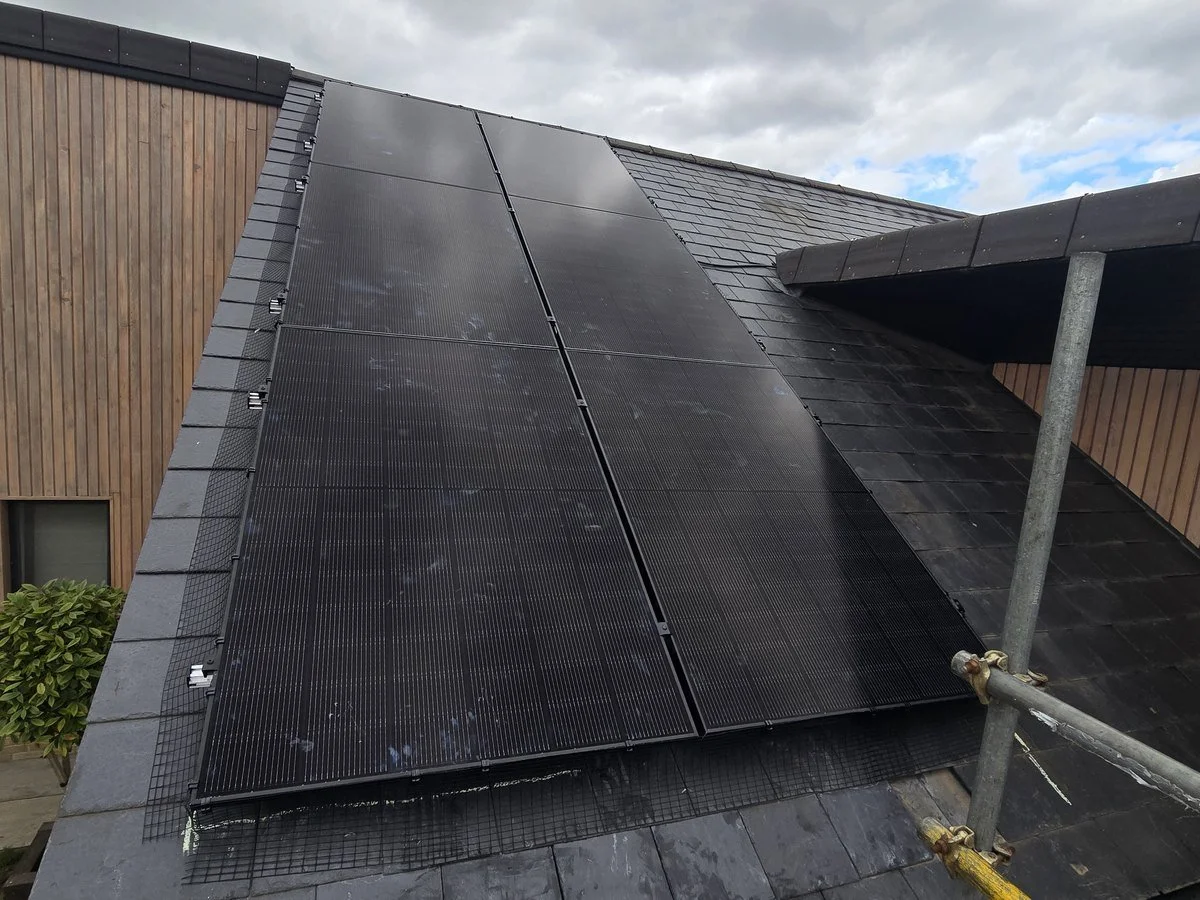 Solar panels installed on a sloped roof next to a scaffold.