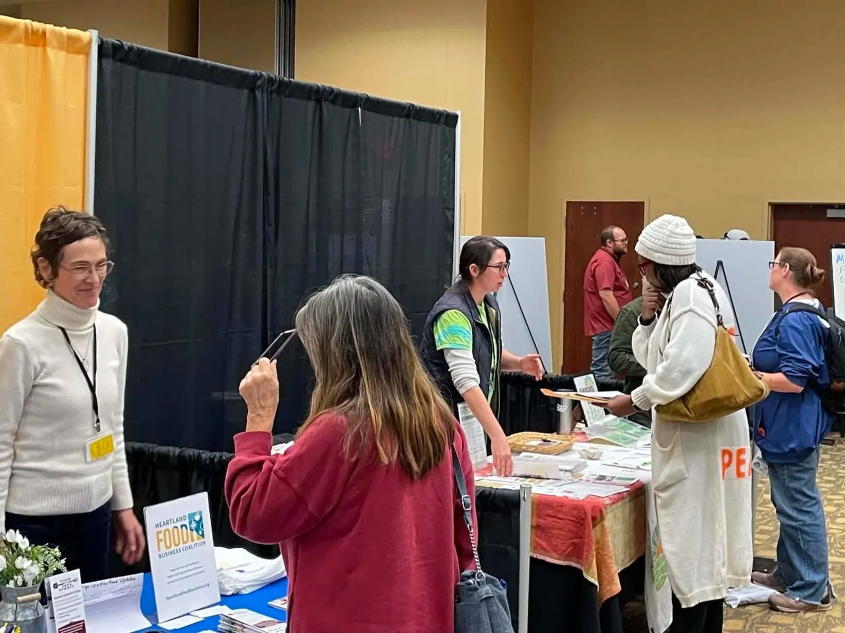 Trade show attendees speak to vendors.