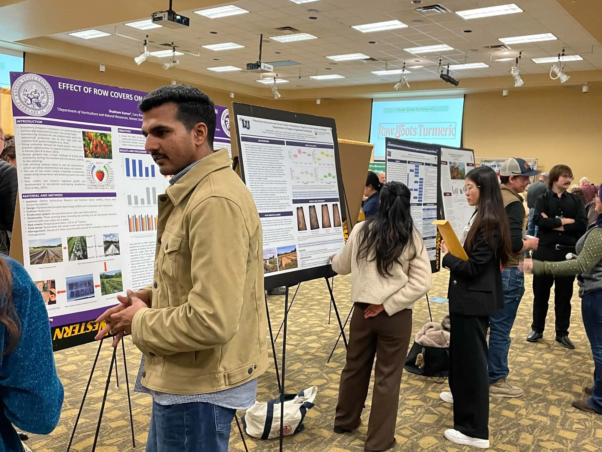 Guests interact with poster presenters at the trade show.