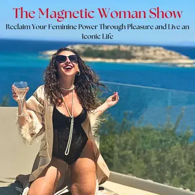 A woman in sunglasses and a black outfit with a beige blazer, holding a glass of wine, smiling at the camera with a scenic ocean view in the background.