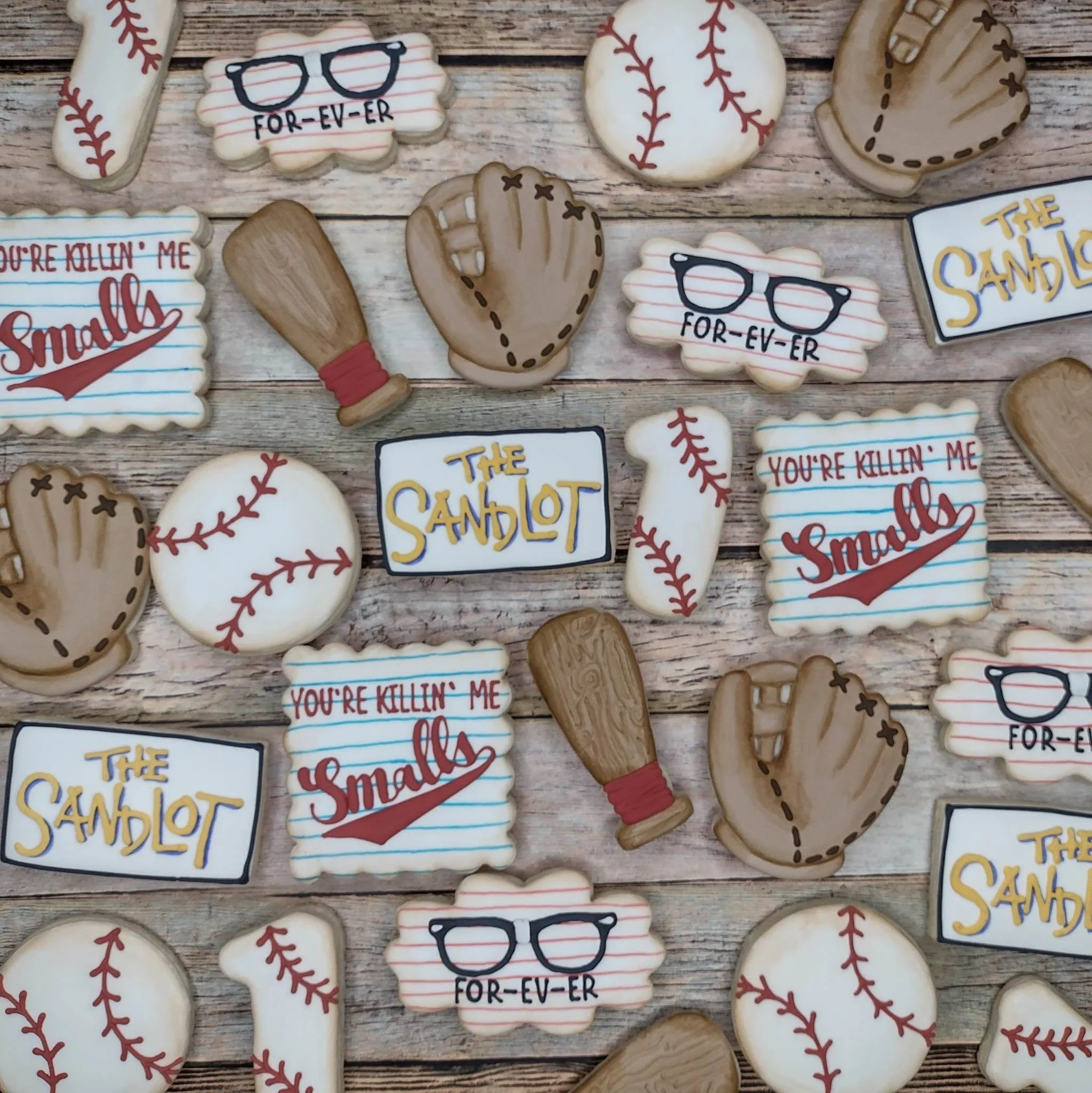 Decorative cookies with The Sandlot baseball-related theme and quotes on a wooden surface.