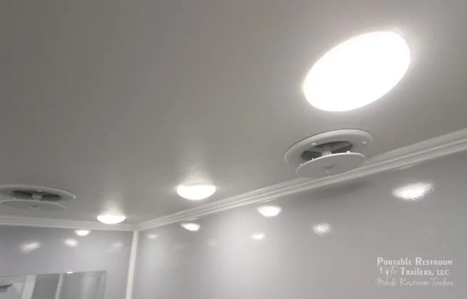 Ceiling with multiple round LED lights and a ceiling vent.