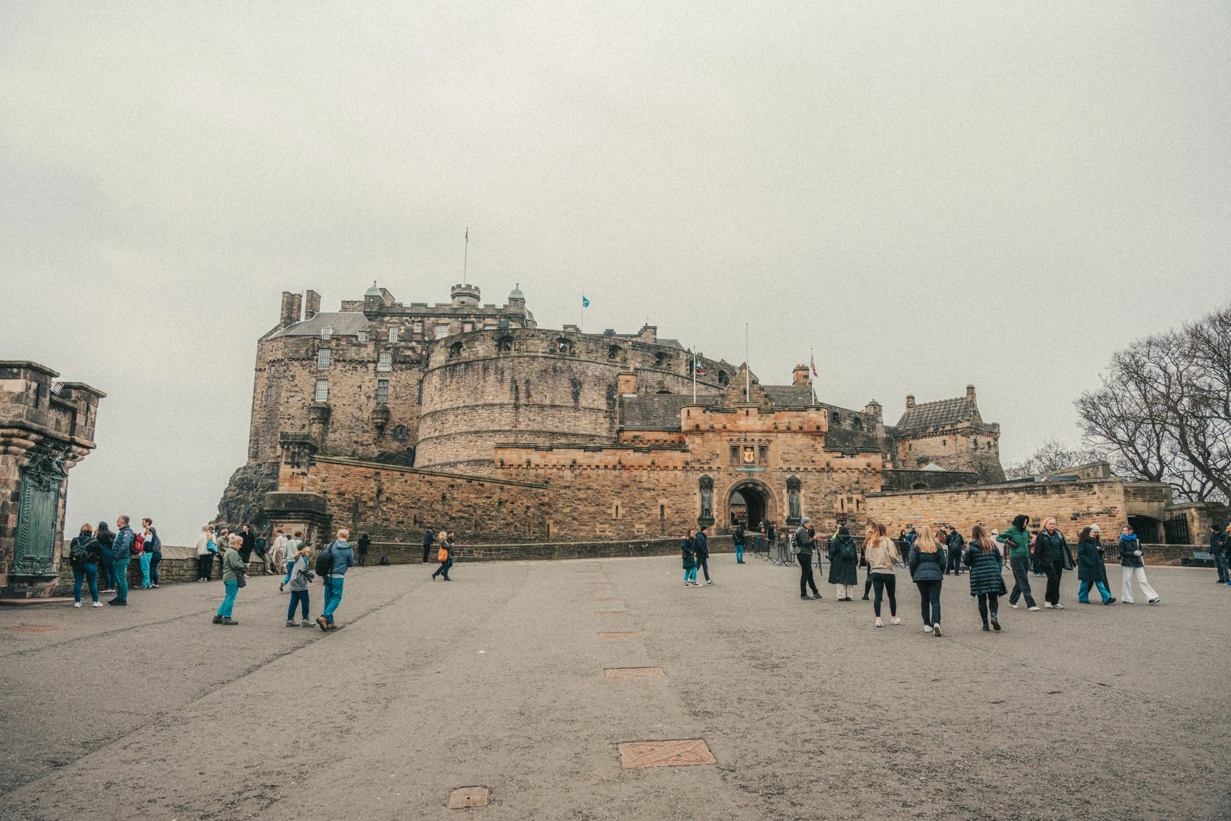Crowd of tourists near Edinburgh Castle on an overcast day.