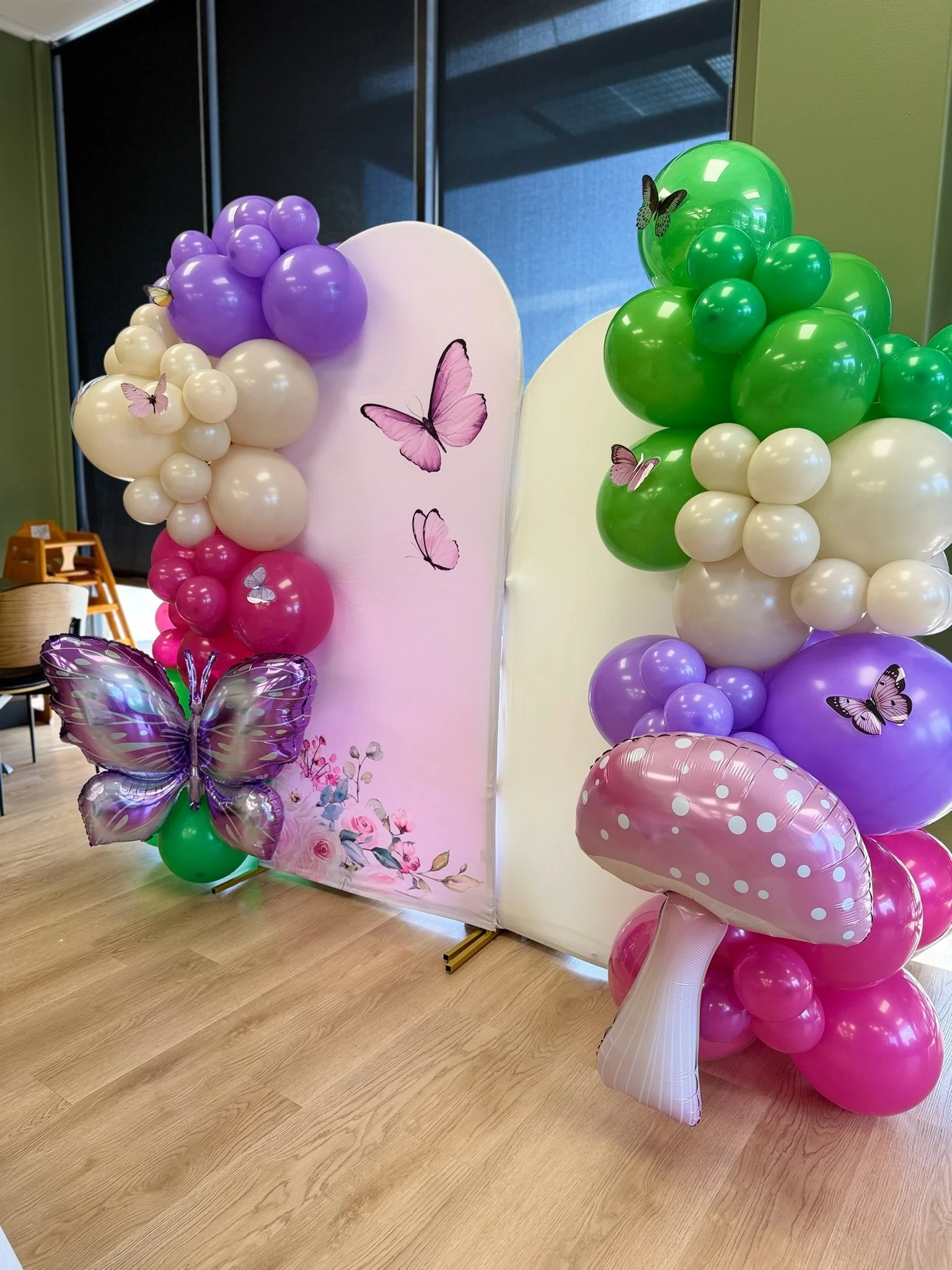 Colorful balloon decorations with butterflies and floral designs for a celebration or event.