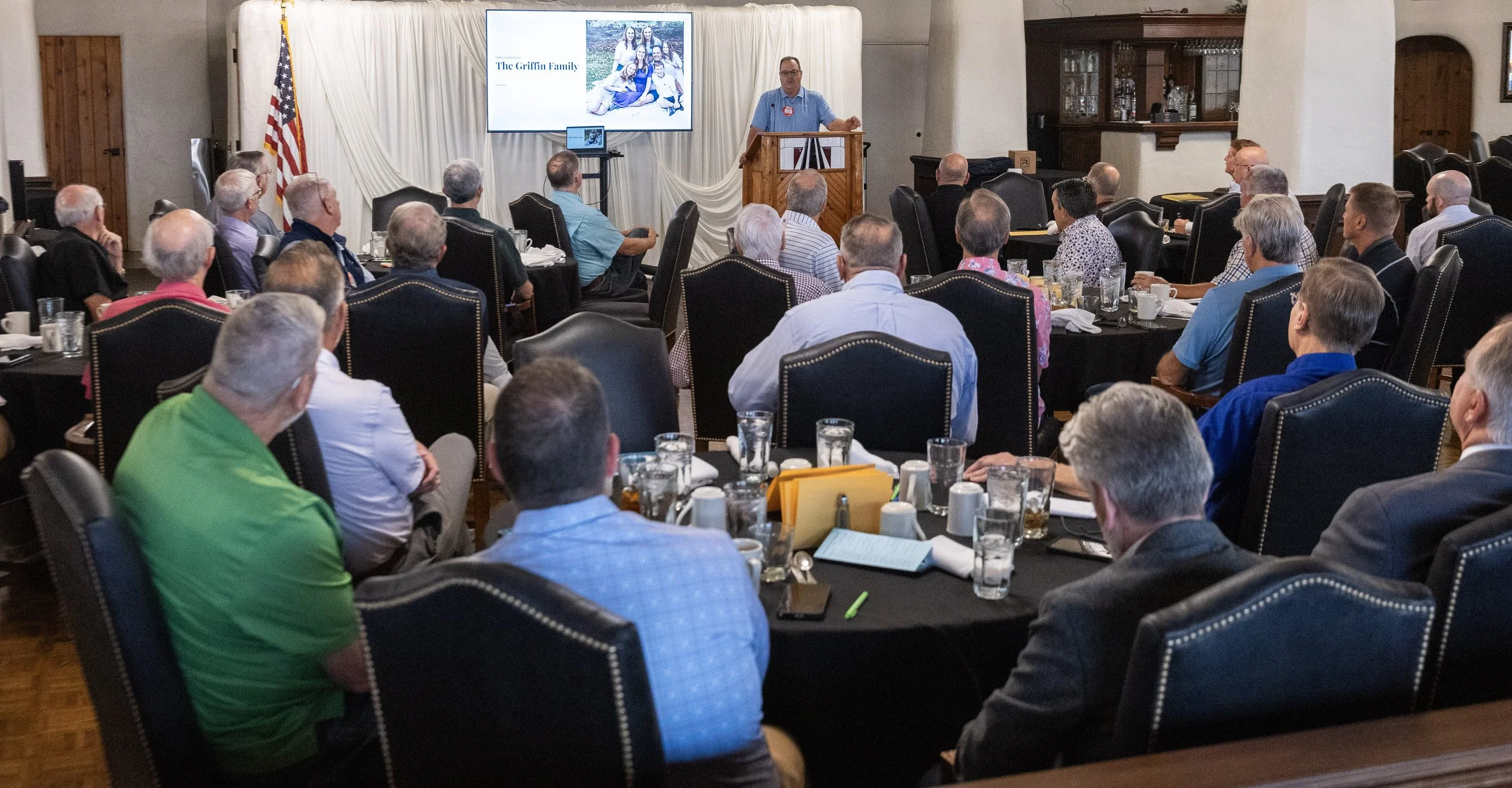 A speaker addresses members from a podium during a Wichita Executives’ Association Spotlight presentation.