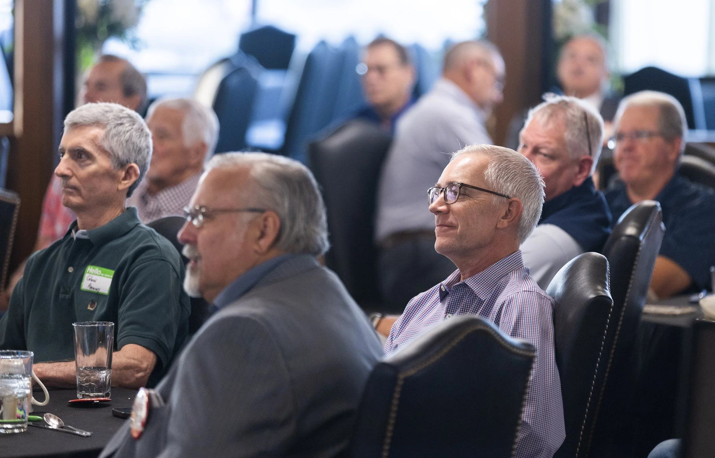 Wichita Executives’ Association members seated at a table listening to a presentation.