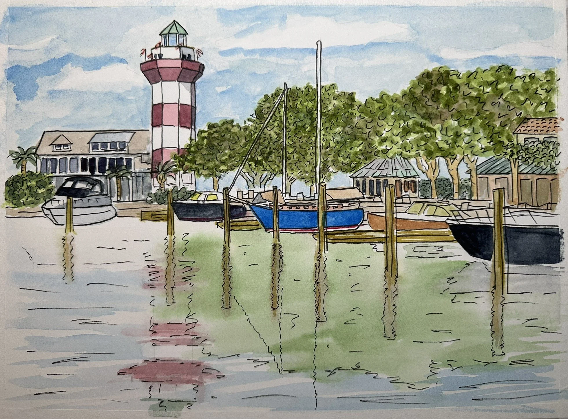Waterfront scene with boats docked, a lighthouse with red and white stripes, trees, and buildings under a partly cloudy sky.