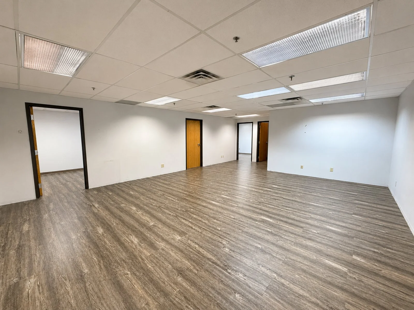 Large office space with wood flooring.