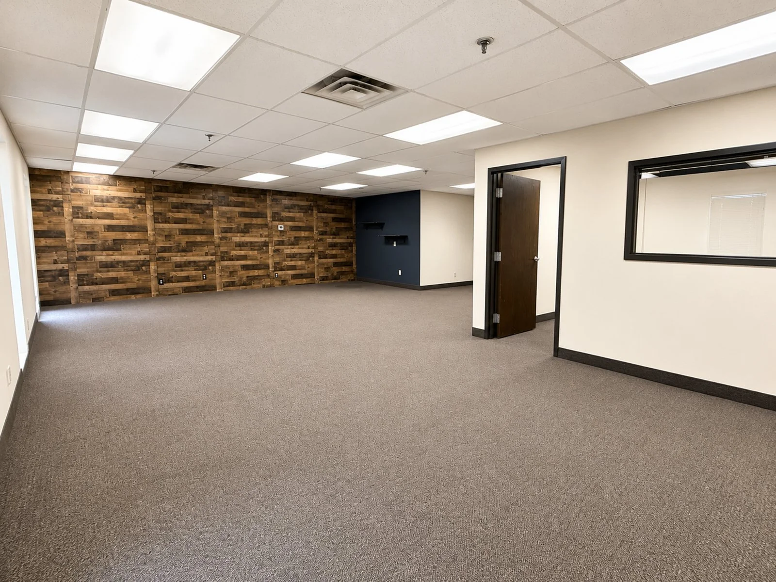 Large office room with a wood accent wall.