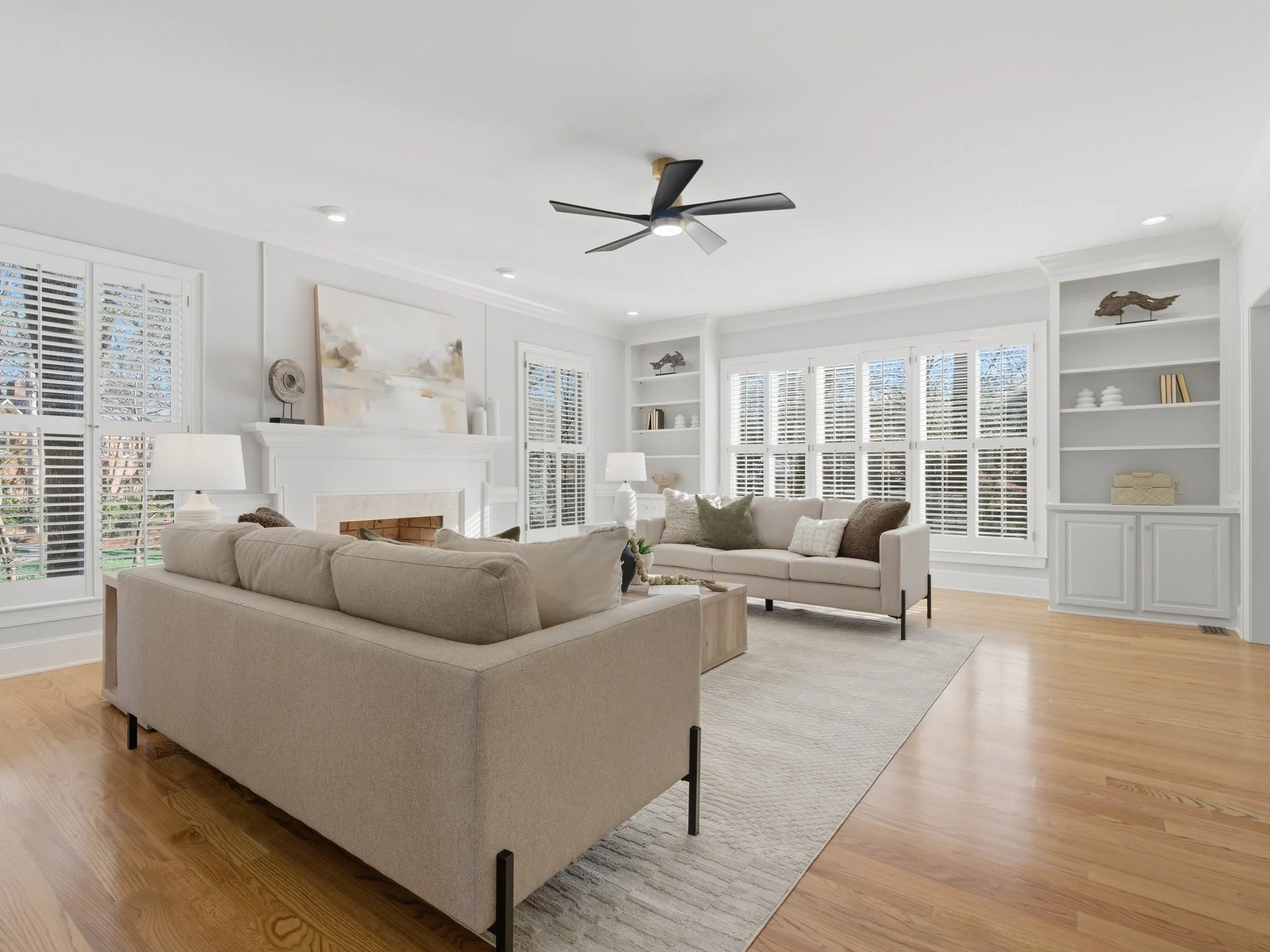 Staged living room with facing couches and fireplace