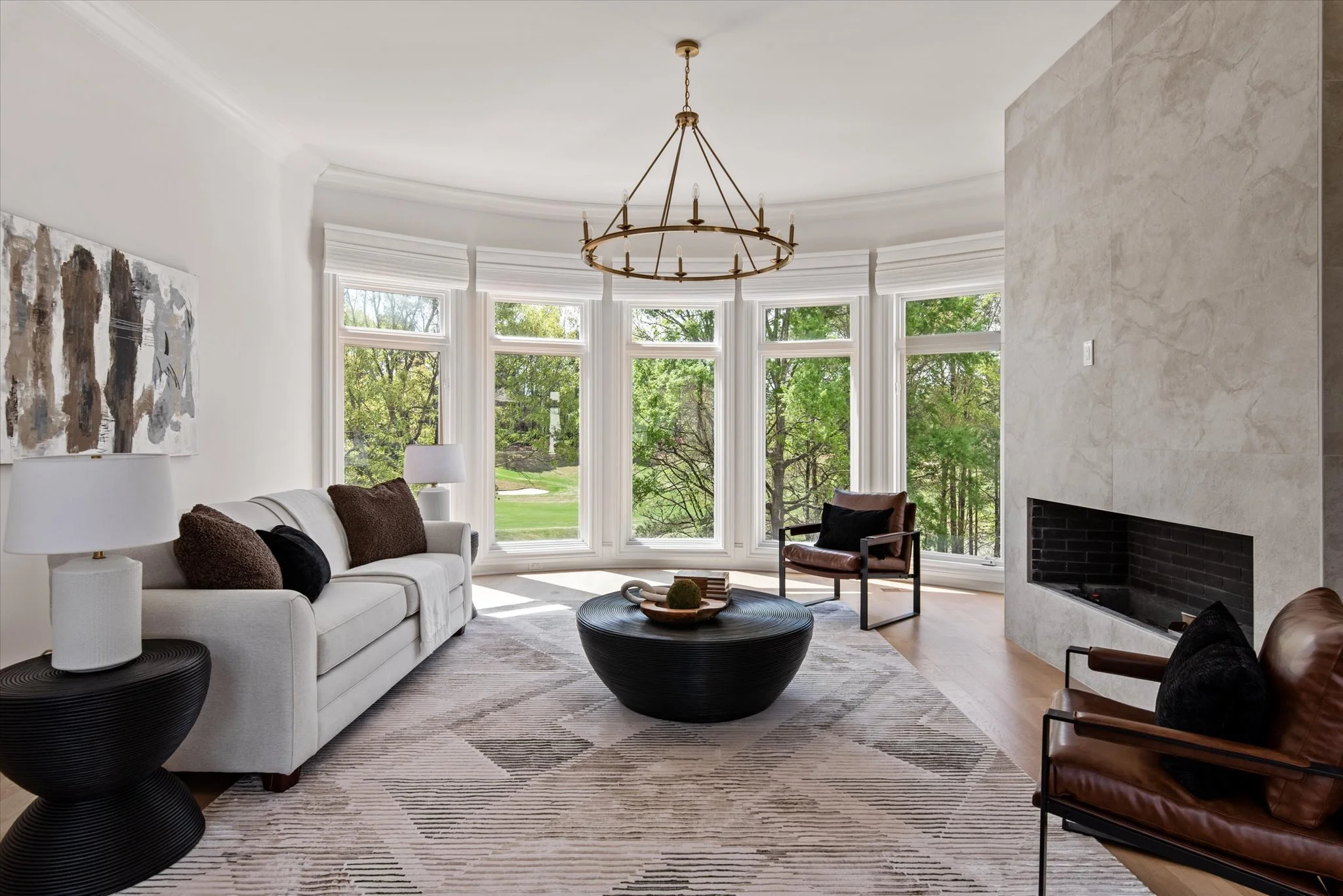 Staged keeping room with bay windows and neutral seating