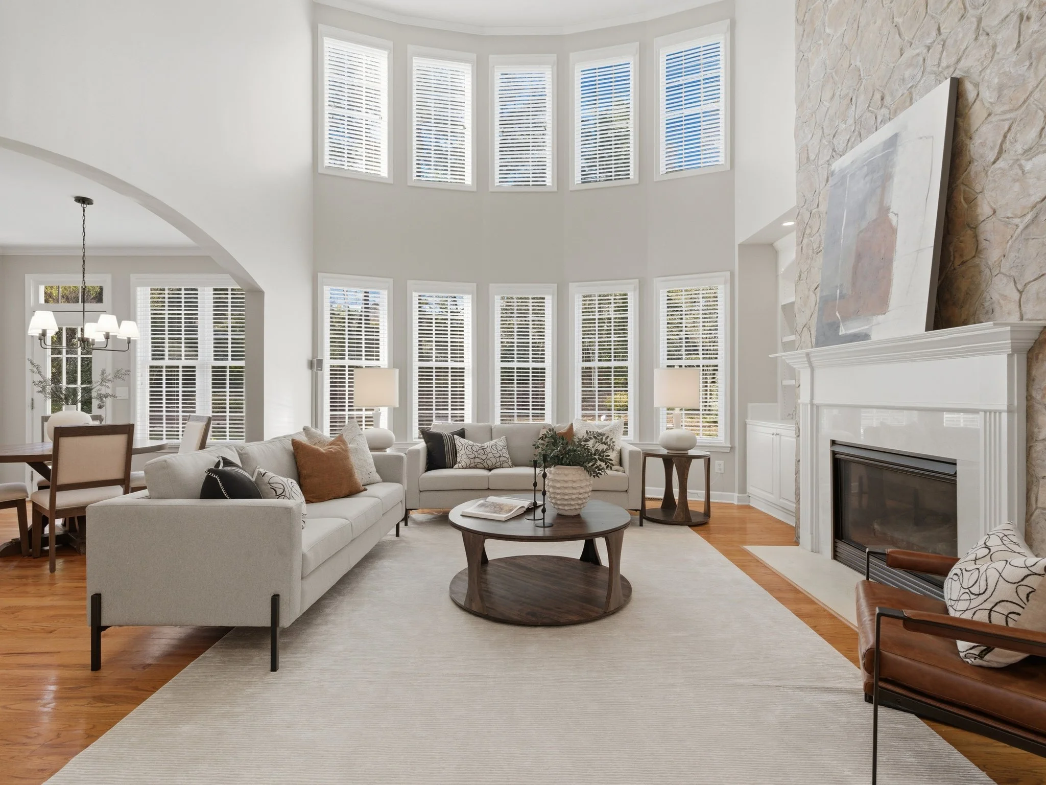 Staged two-story living room with floor-to-ceiling windows