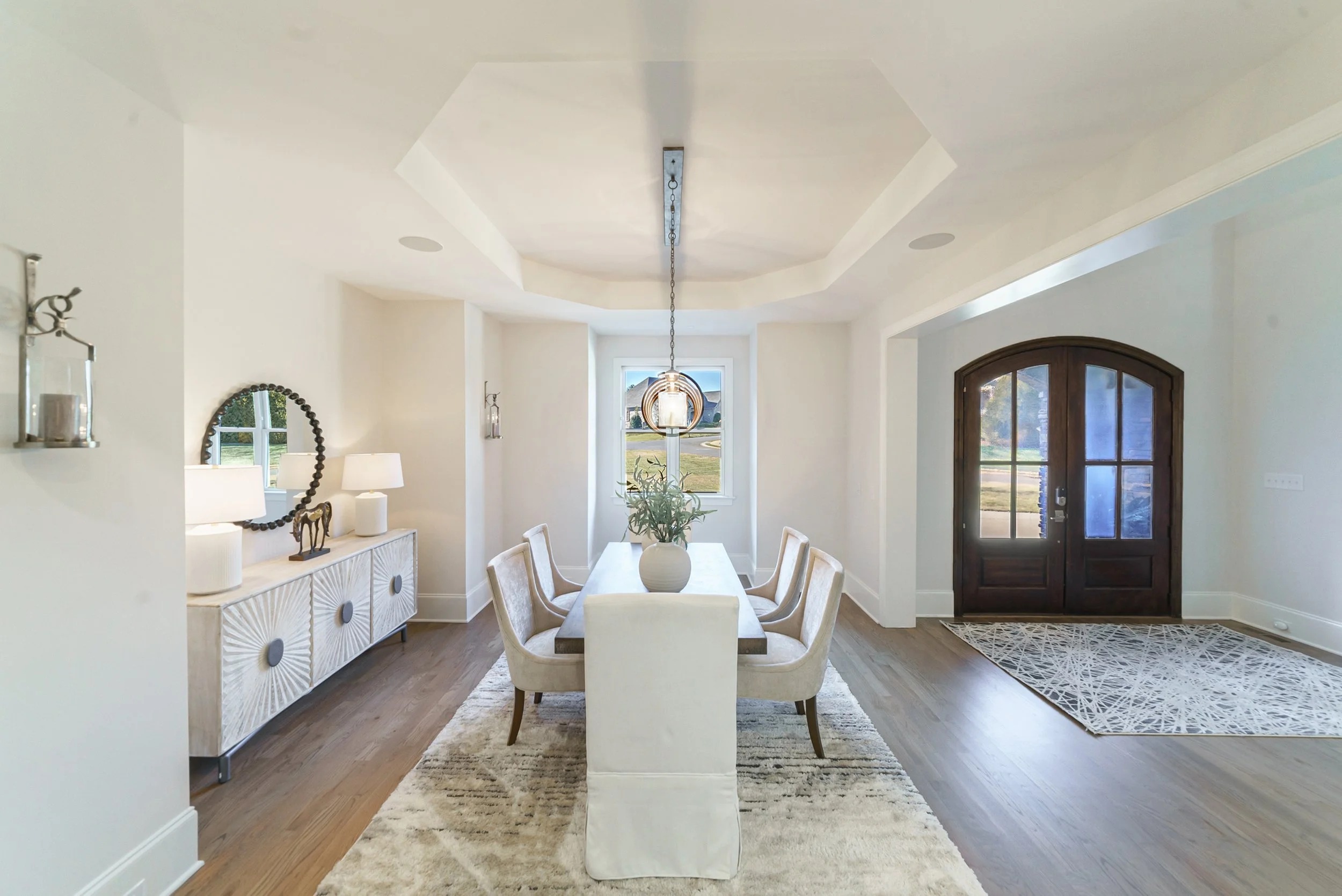 Staged foyer with arched front door and dining table, Weddington NC