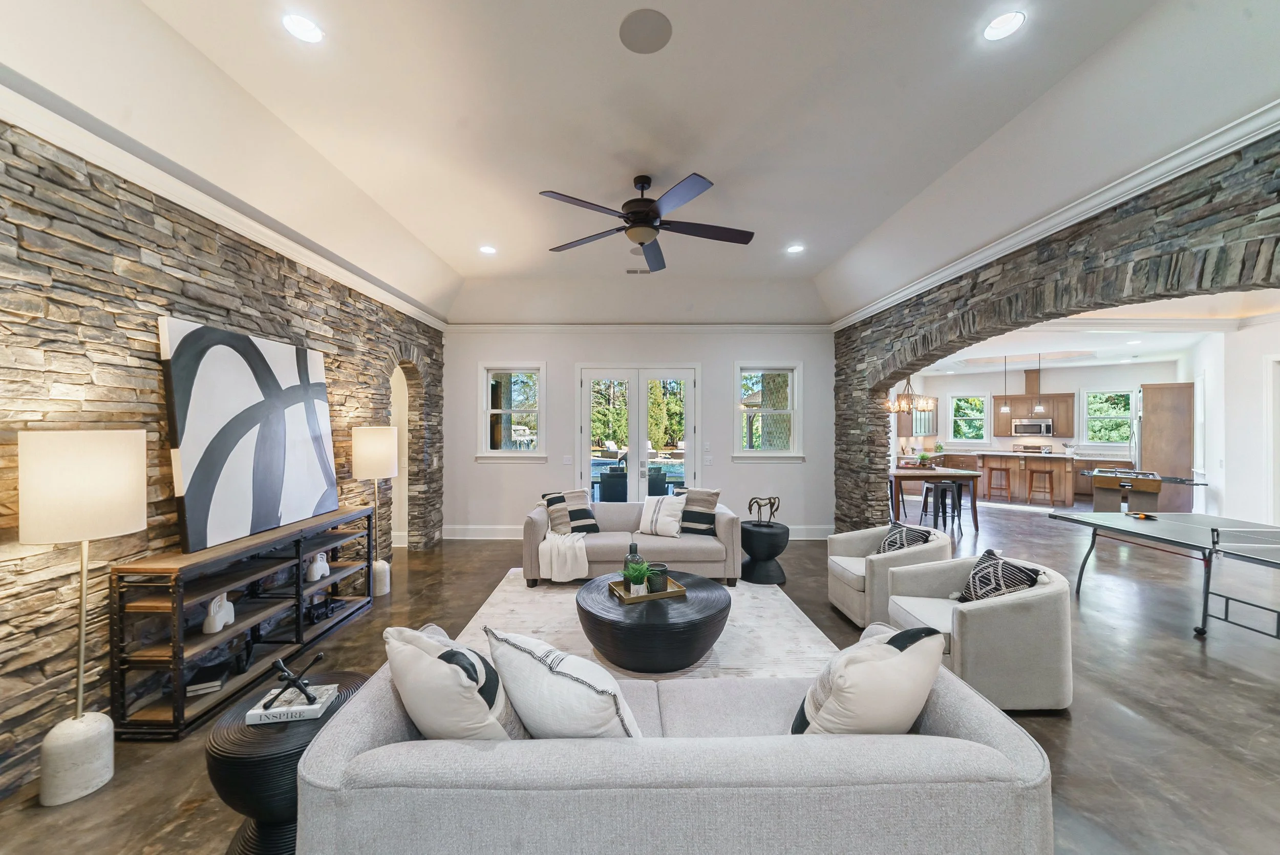 Staged rec room open to kitchen with ping pong table