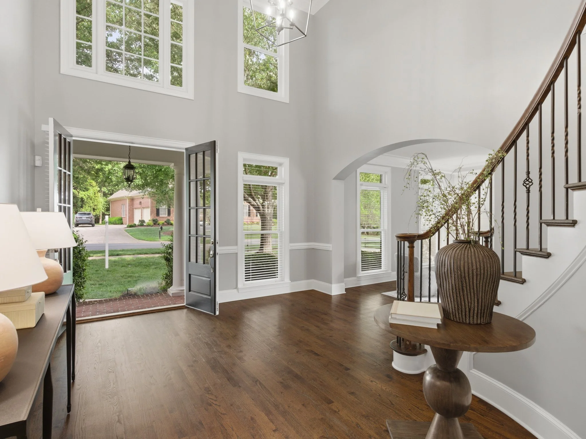Staged foyer with curved staircase and open front door, Charlotte NC