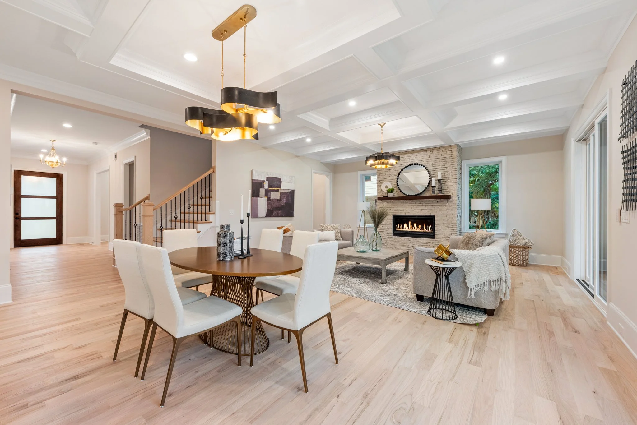 Staged open dining and living space with stone fireplace