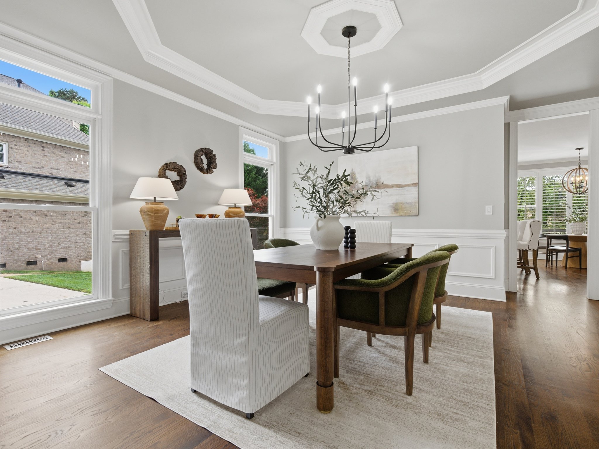 Staged dining room with wood table and green accent chairs