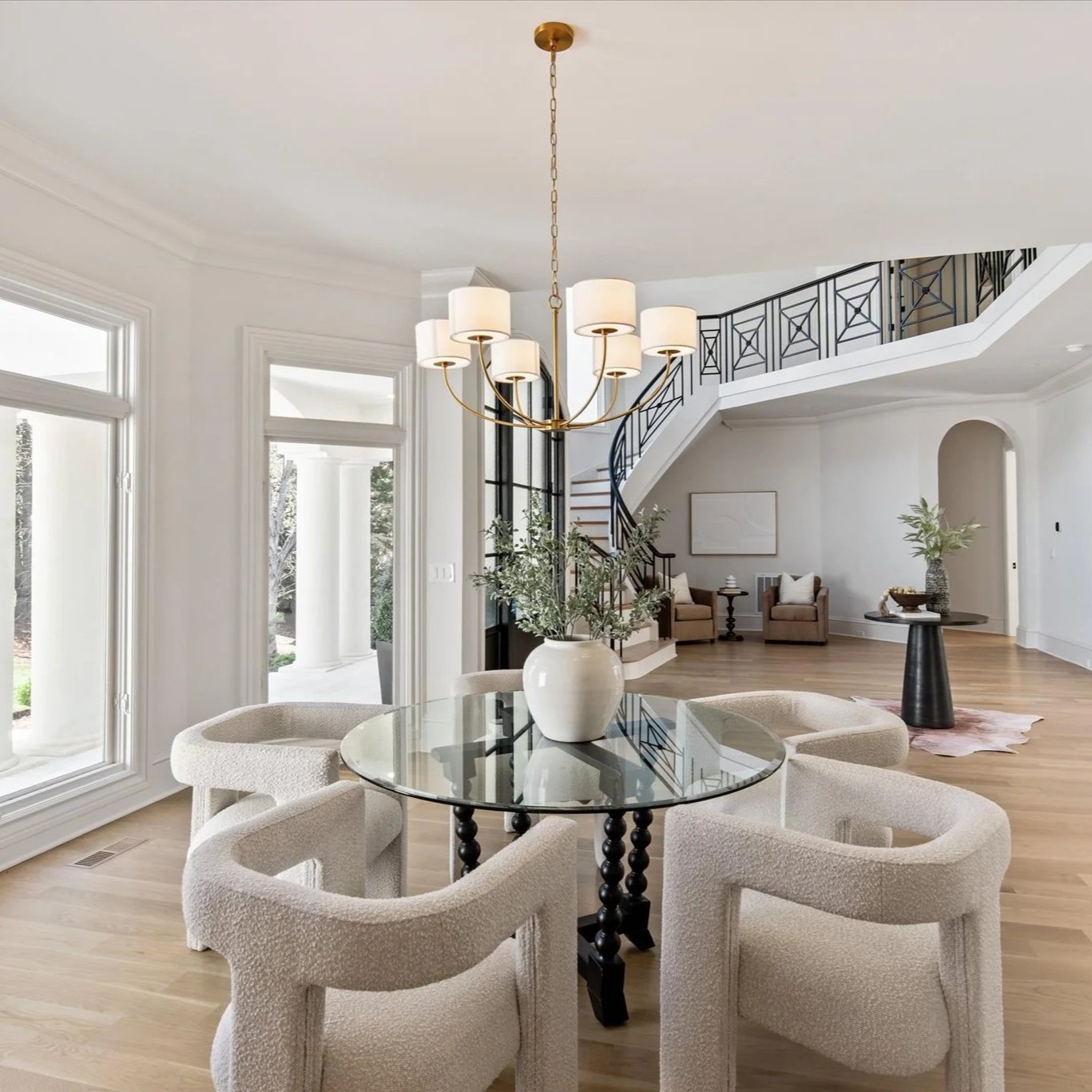 Staged entryway with round table, boucle chairs, and staircase