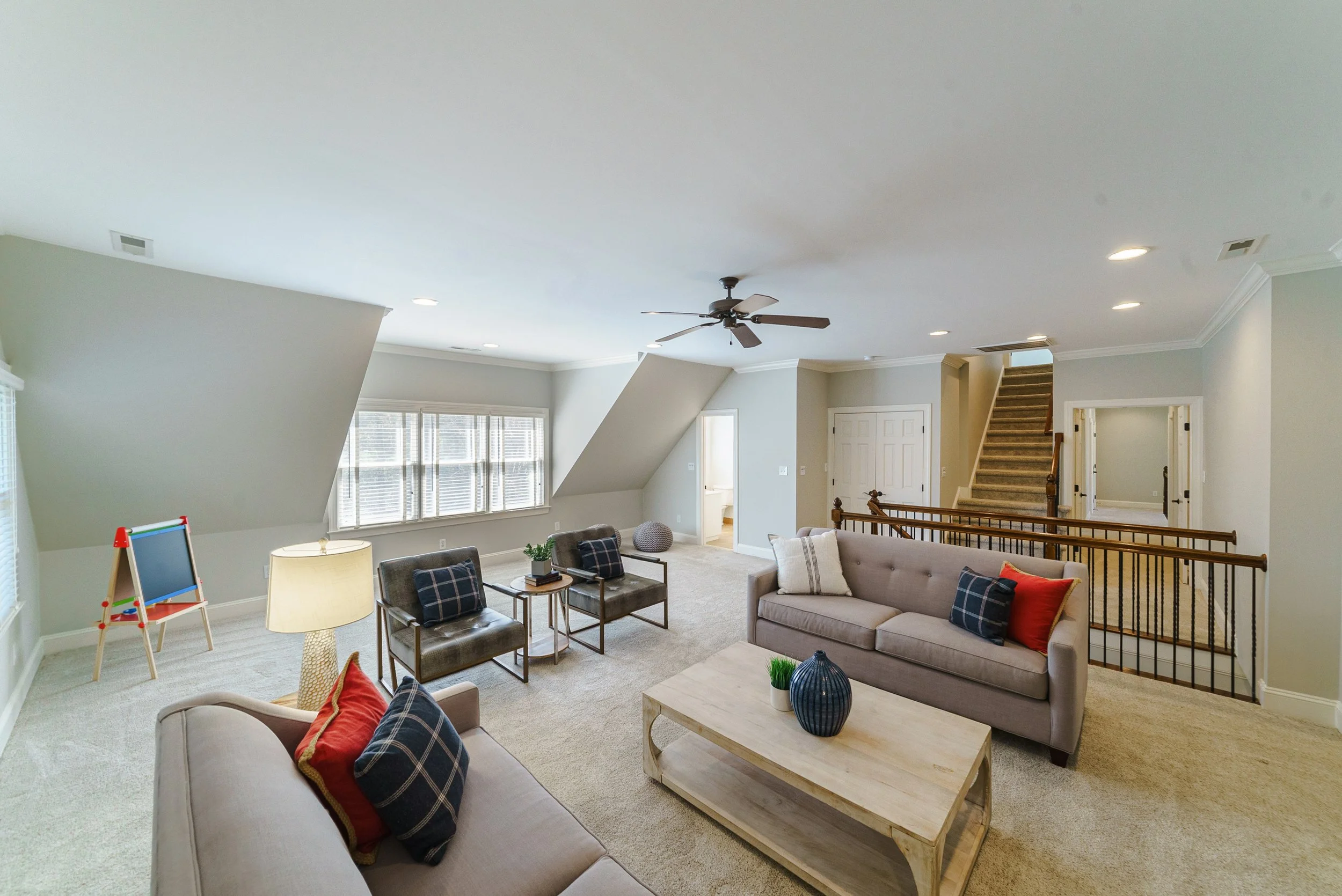 Staged bonus room with sectional seating and craft area