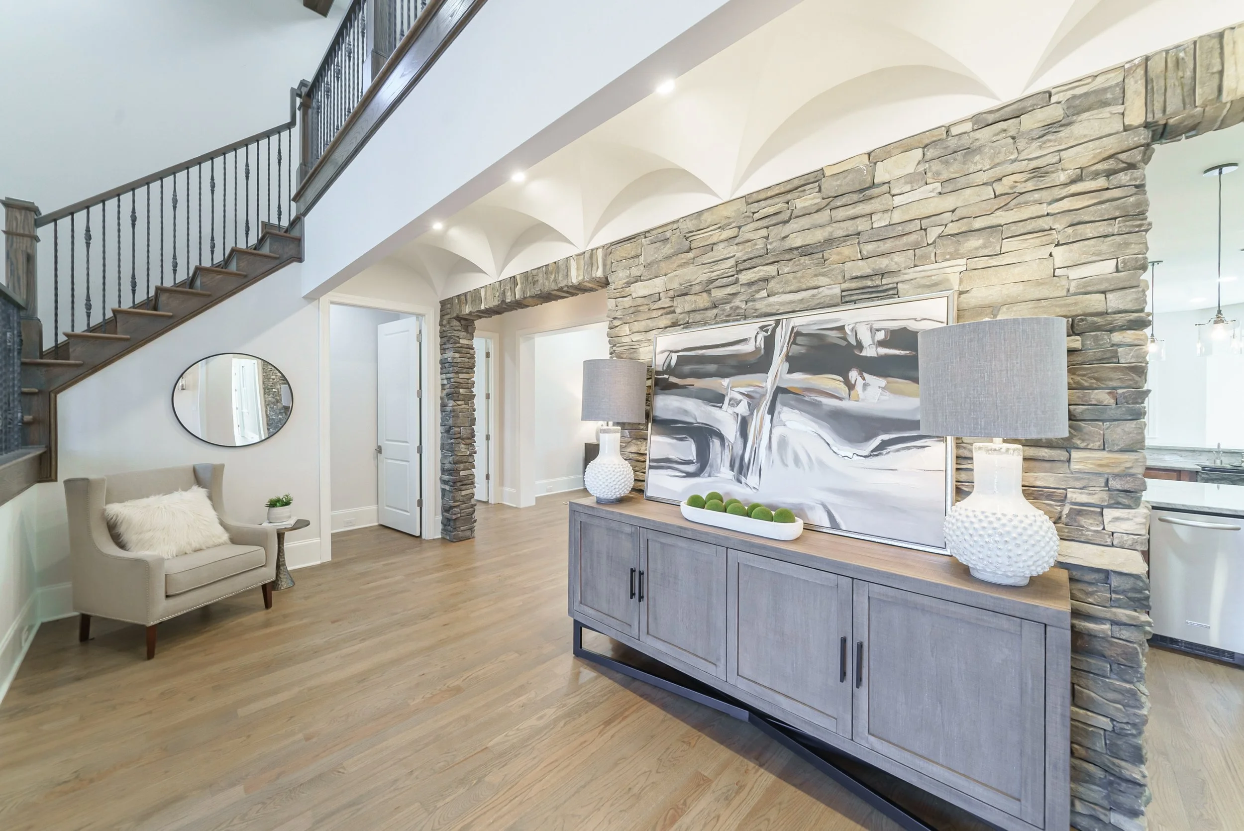 Staged foyer with curved staircase and console table