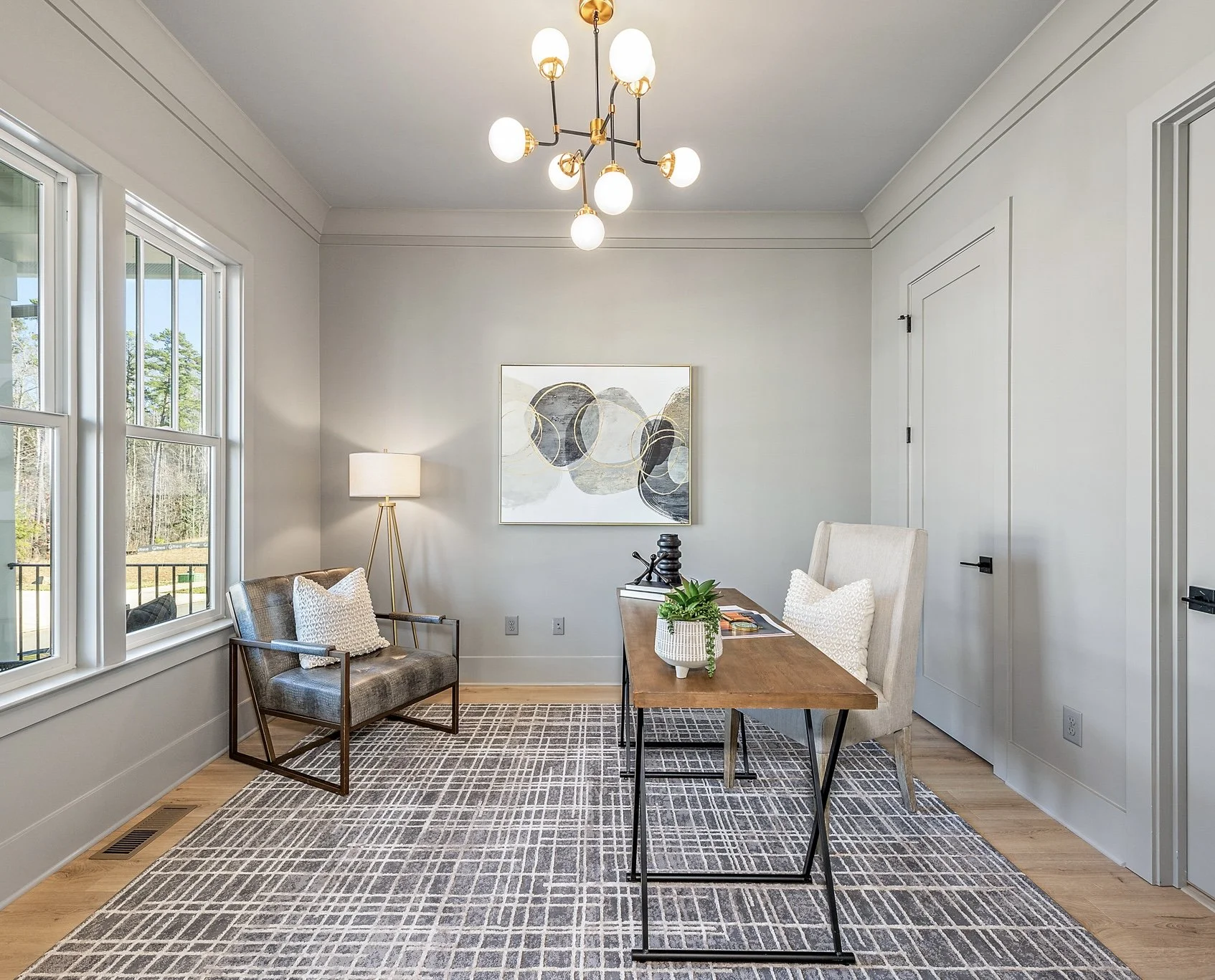 Staged home office with abstract art and wingback chair