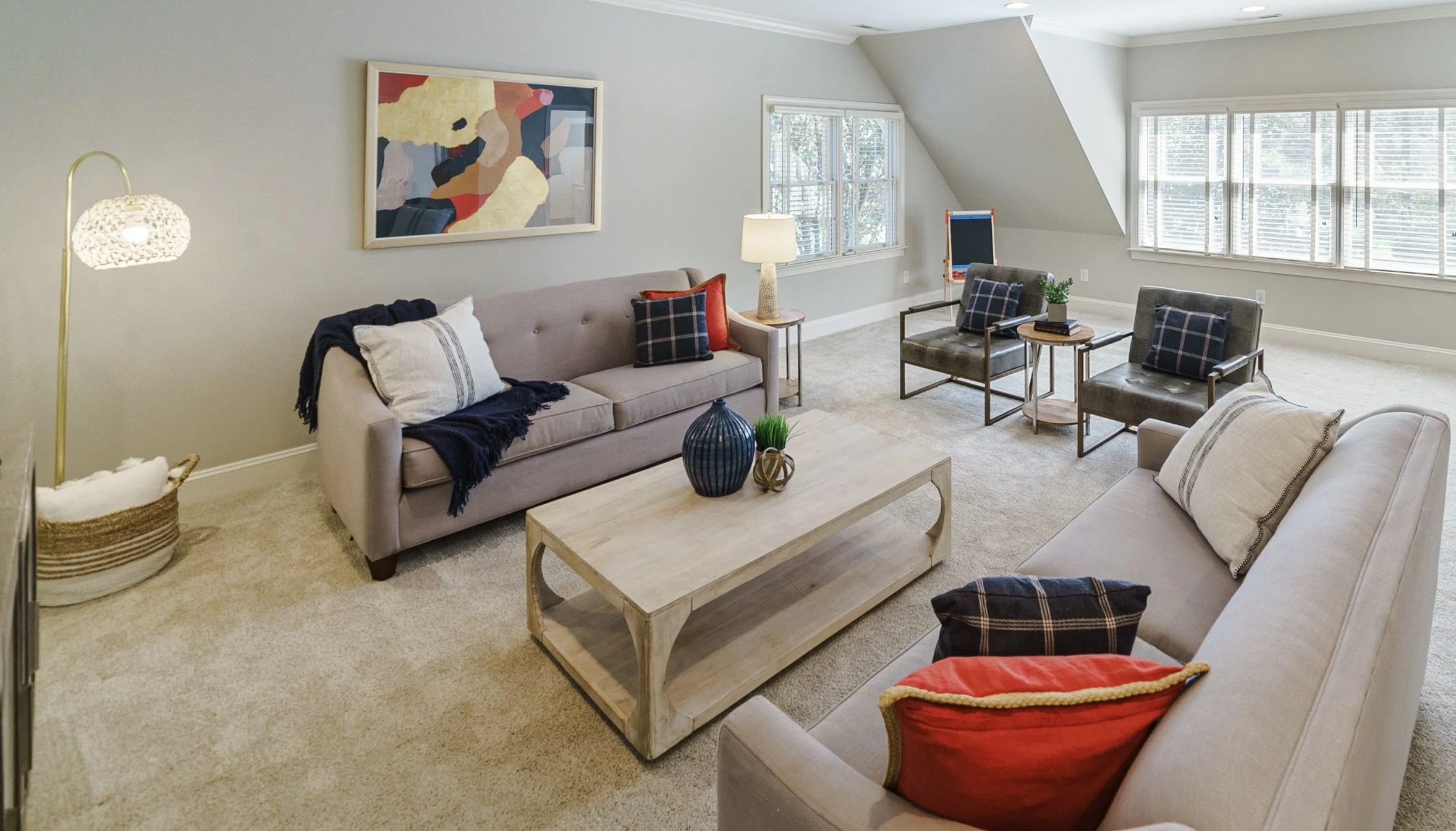 Staged bonus room with modern sectional and abstract art, Charlotte NC