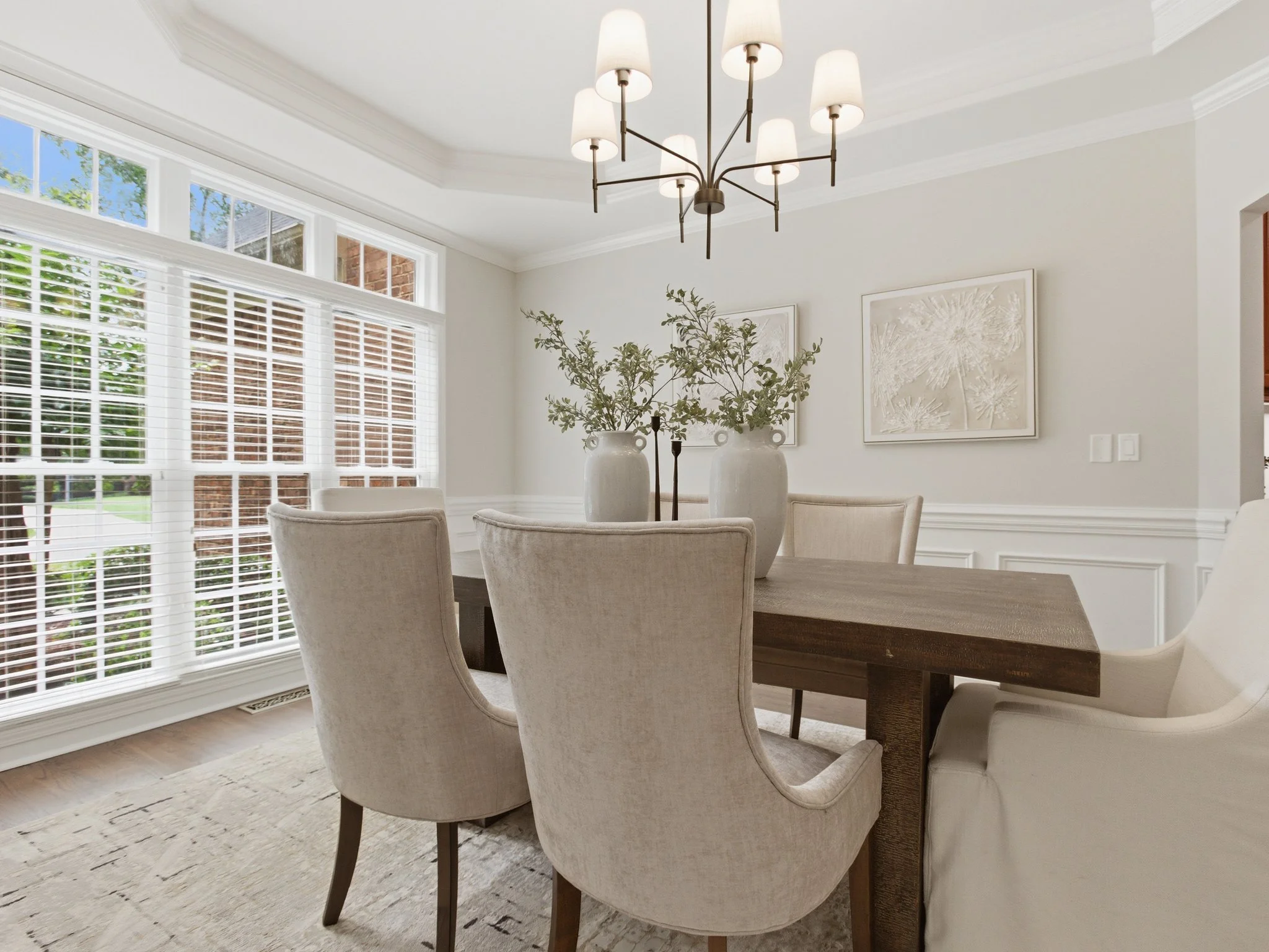 Staged dining room with tall windows and neutral chairs, Matthews NC