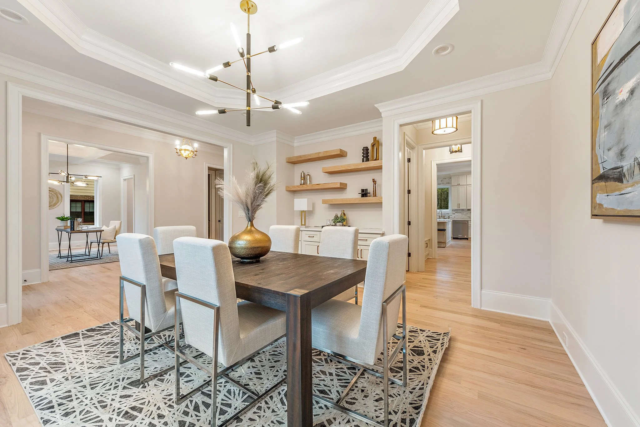 Staged dining room with sculptural chandelier and floating shelves