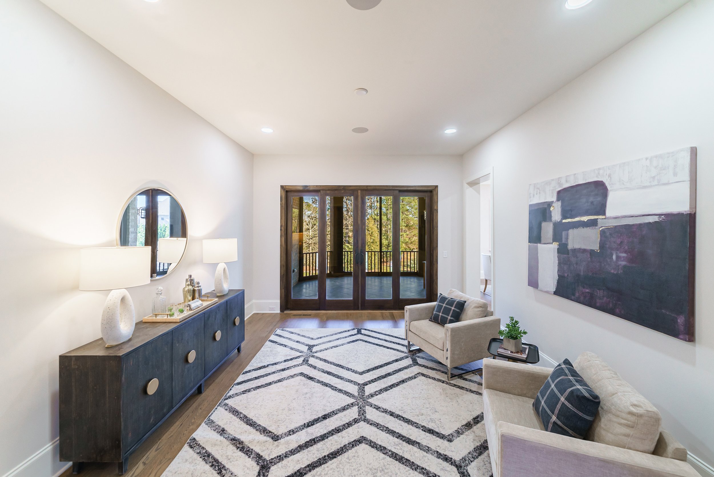 Staged upstairs sitting area with French doors to balcony