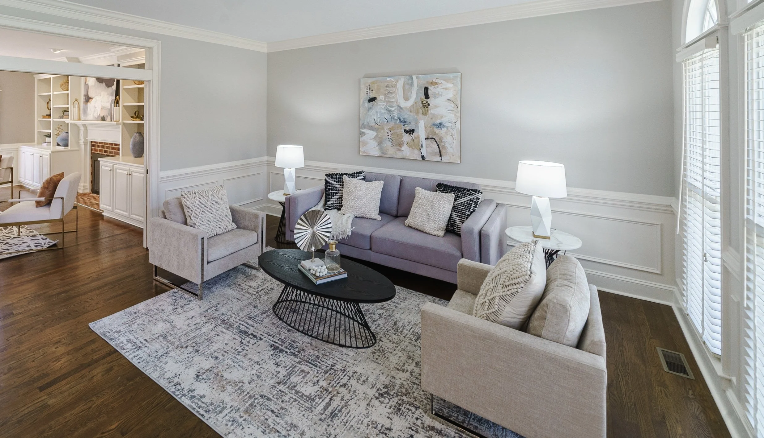 Staged living room with oval coffee table and neutral seating