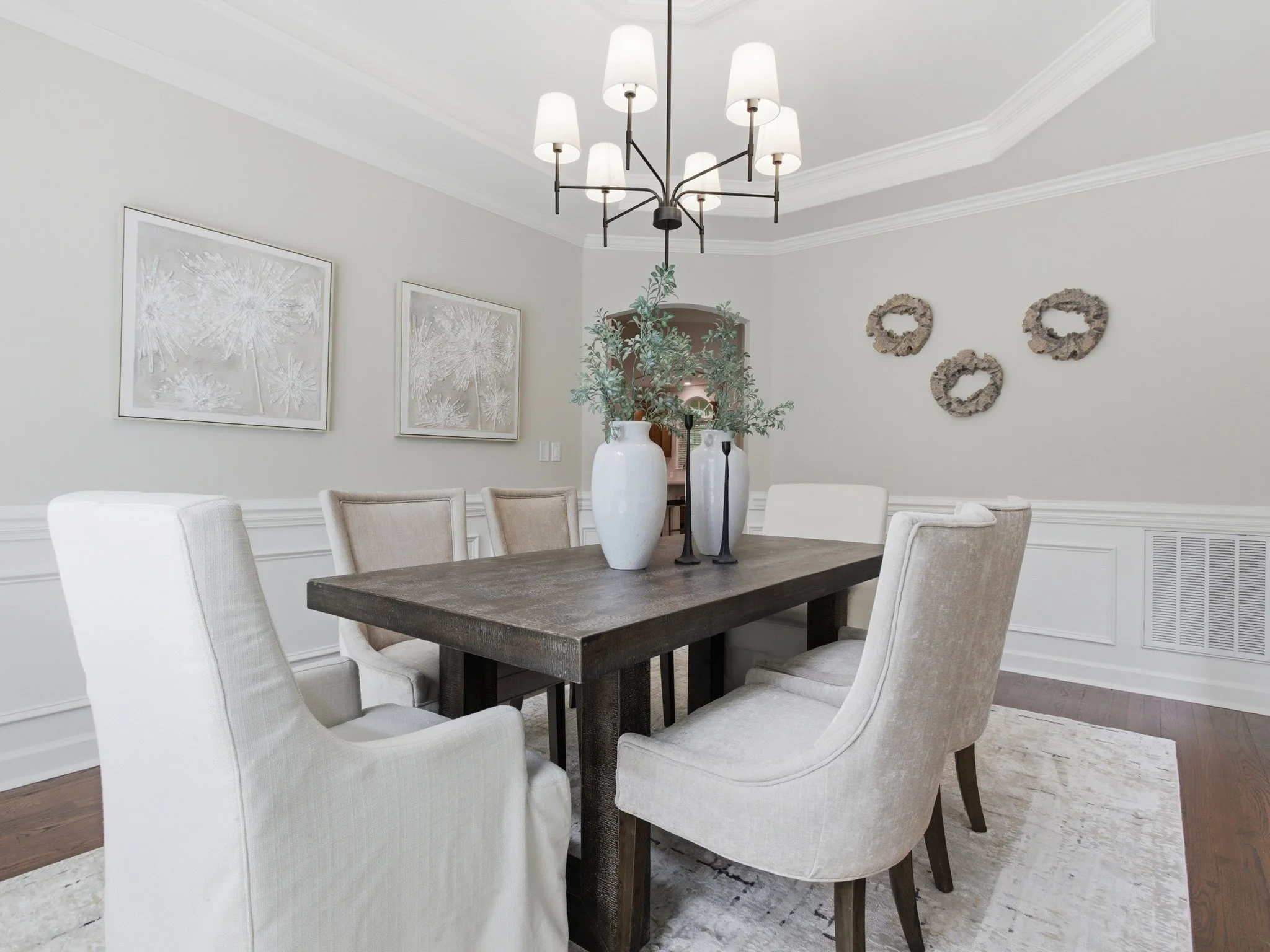 Staged dining room with botanical wall art and slipcovered chairs