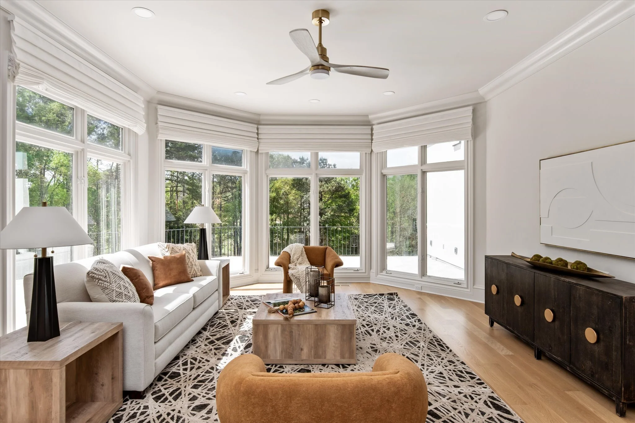 Staged living room with stone fireplace and curved bay windows, Charlotte NC