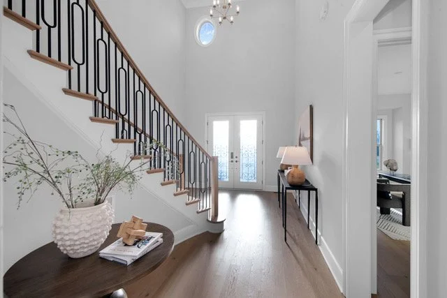 Staged foyer with curved staircase and round table