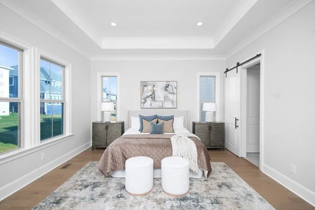 Staged bedroom with barn door and blue accent pillows, Charlotte NC