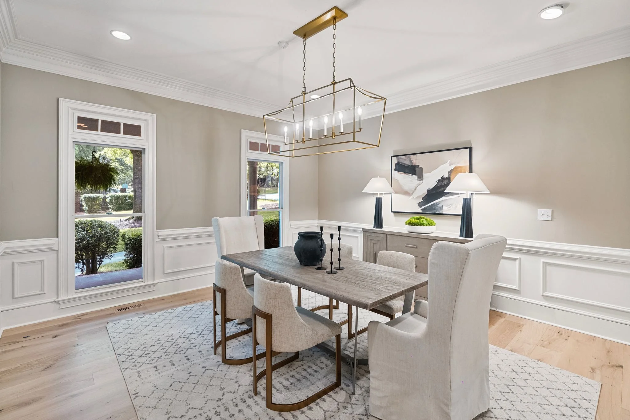 Staged dining room with slipcovered chairs and abstract art