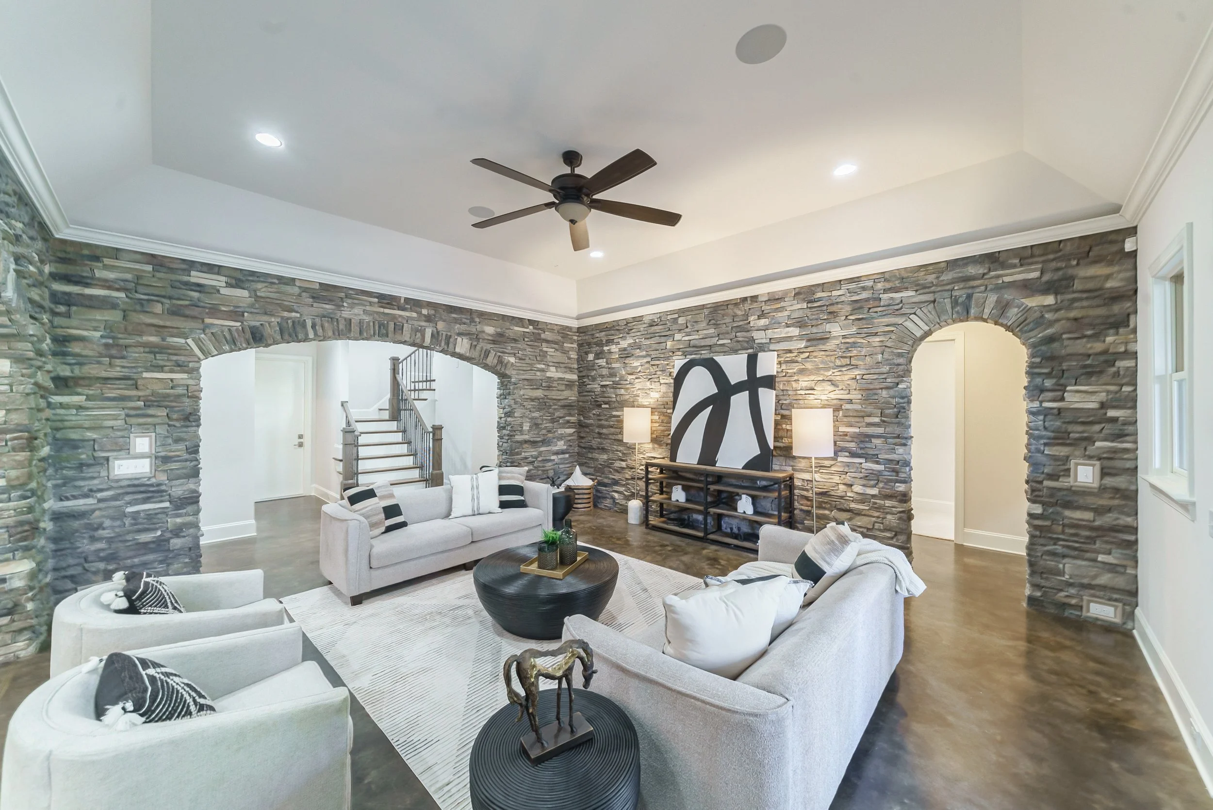 Staged rec room with stacked stone archways and modern seating, Weddington NC