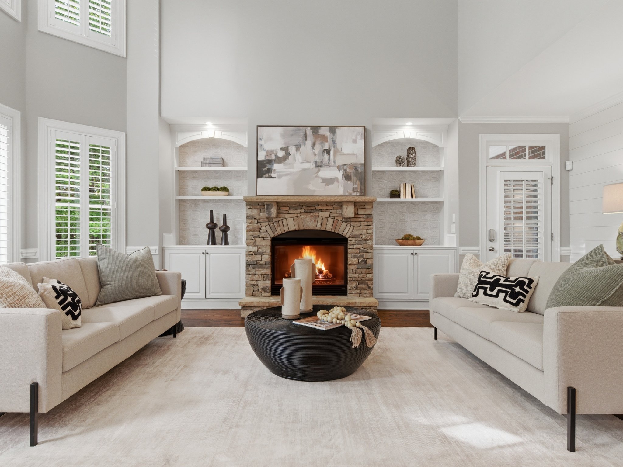 Staged living room with lit fireplace and built-in shelving