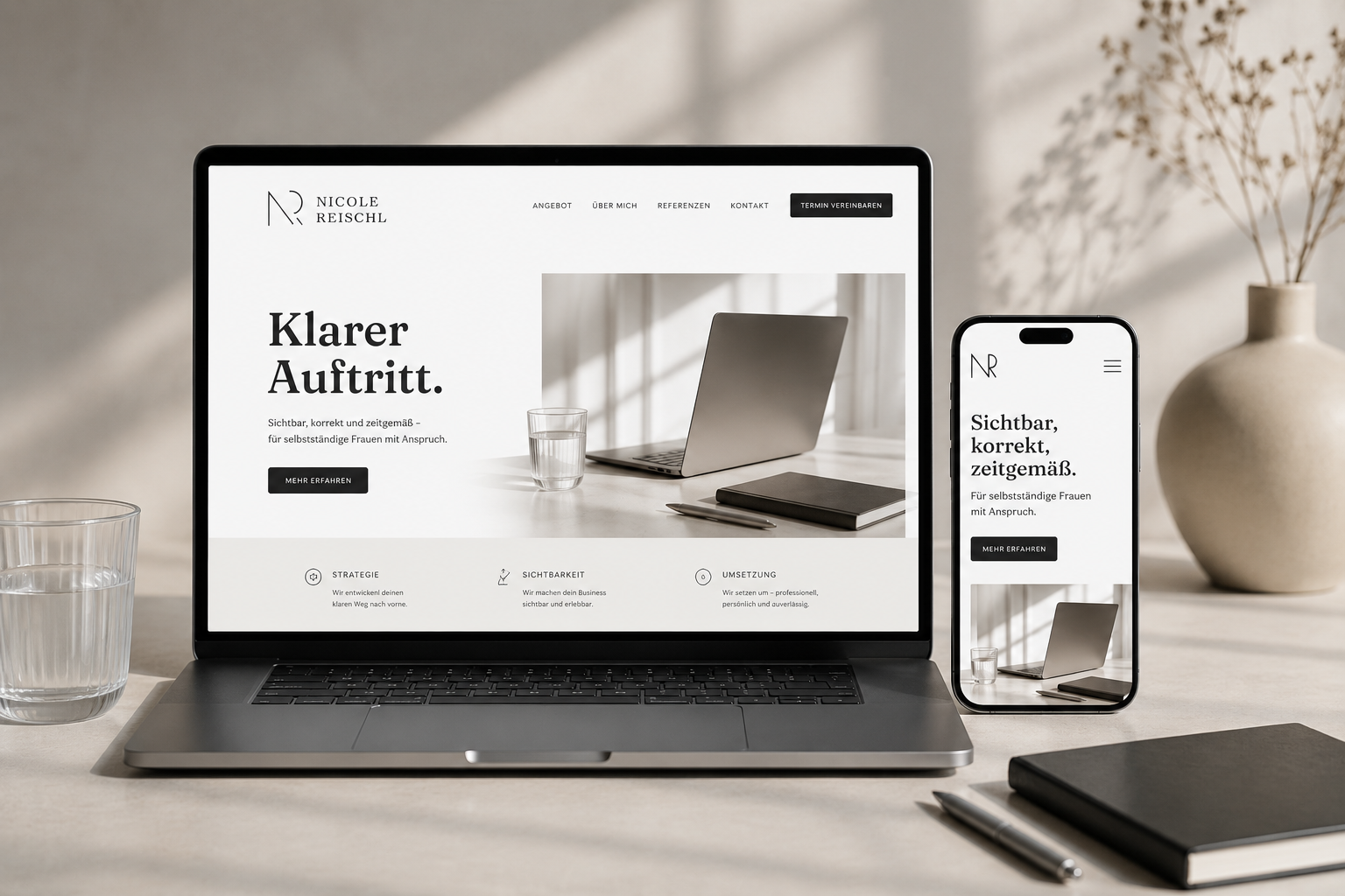 Laptop und Smartphone zeigen eine Webseite mit dem Titel 'Klarer Auftritt' für eine professionelle Frauencoaching-Dienstleistung, auf einem Schreibtisch mit einem Notizbuch, einem Stift, einem Glas Wasser und einer Vase im Hintergrund.
