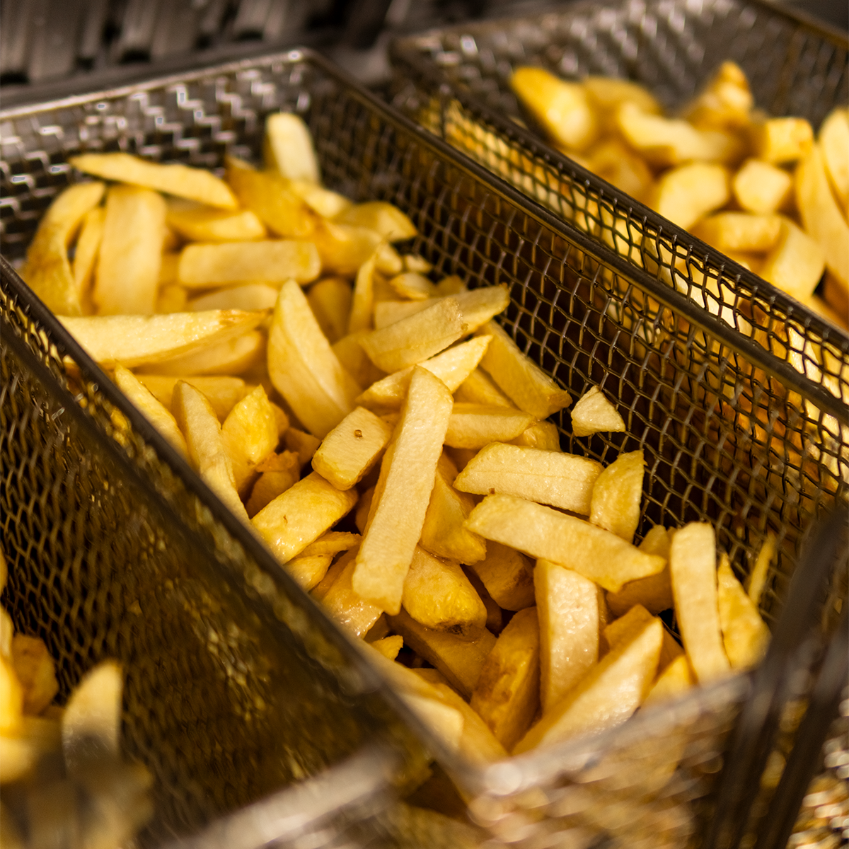 French fries in metal fry baskets.