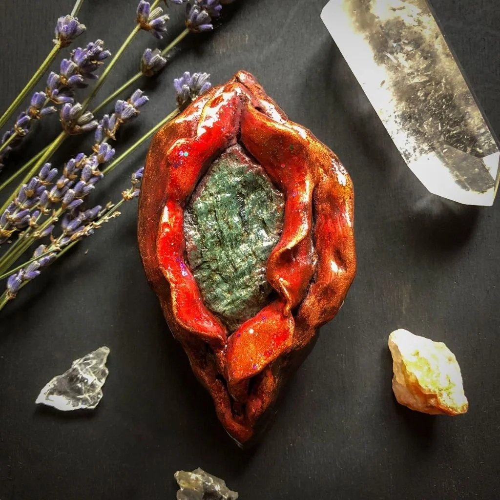 "Menstrual Blood Yoni"    Clay sculpture, acrylic paint, serpentinite stone and glitter.