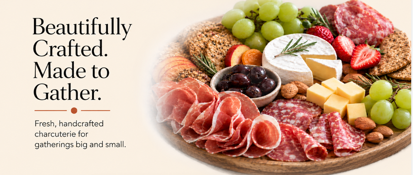 A cheese and charcuterie board with grapes, strawberries, almonds, crackers, cheese, salami, and prosciutto.