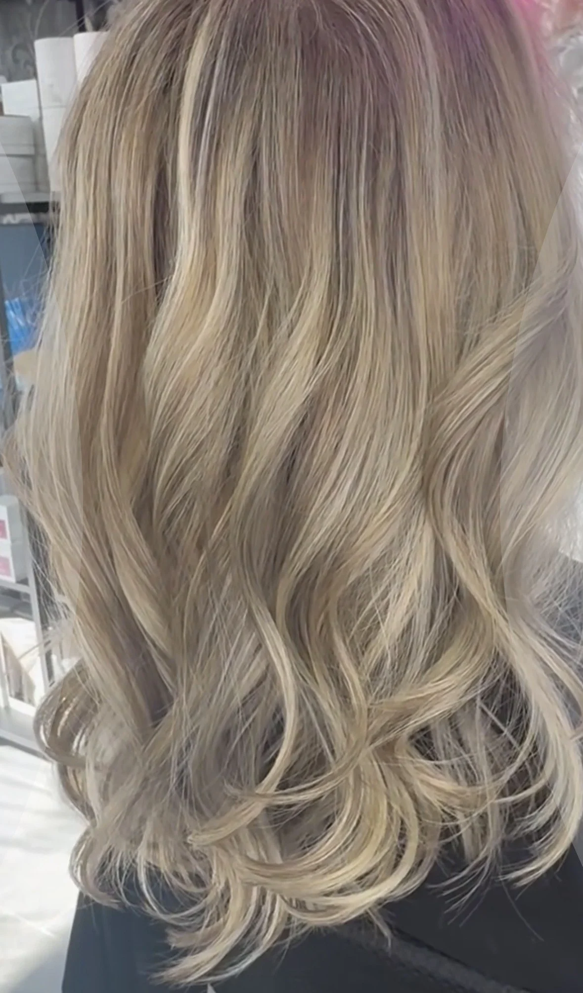 Blonde hair styled in loose curls, viewed from the back.