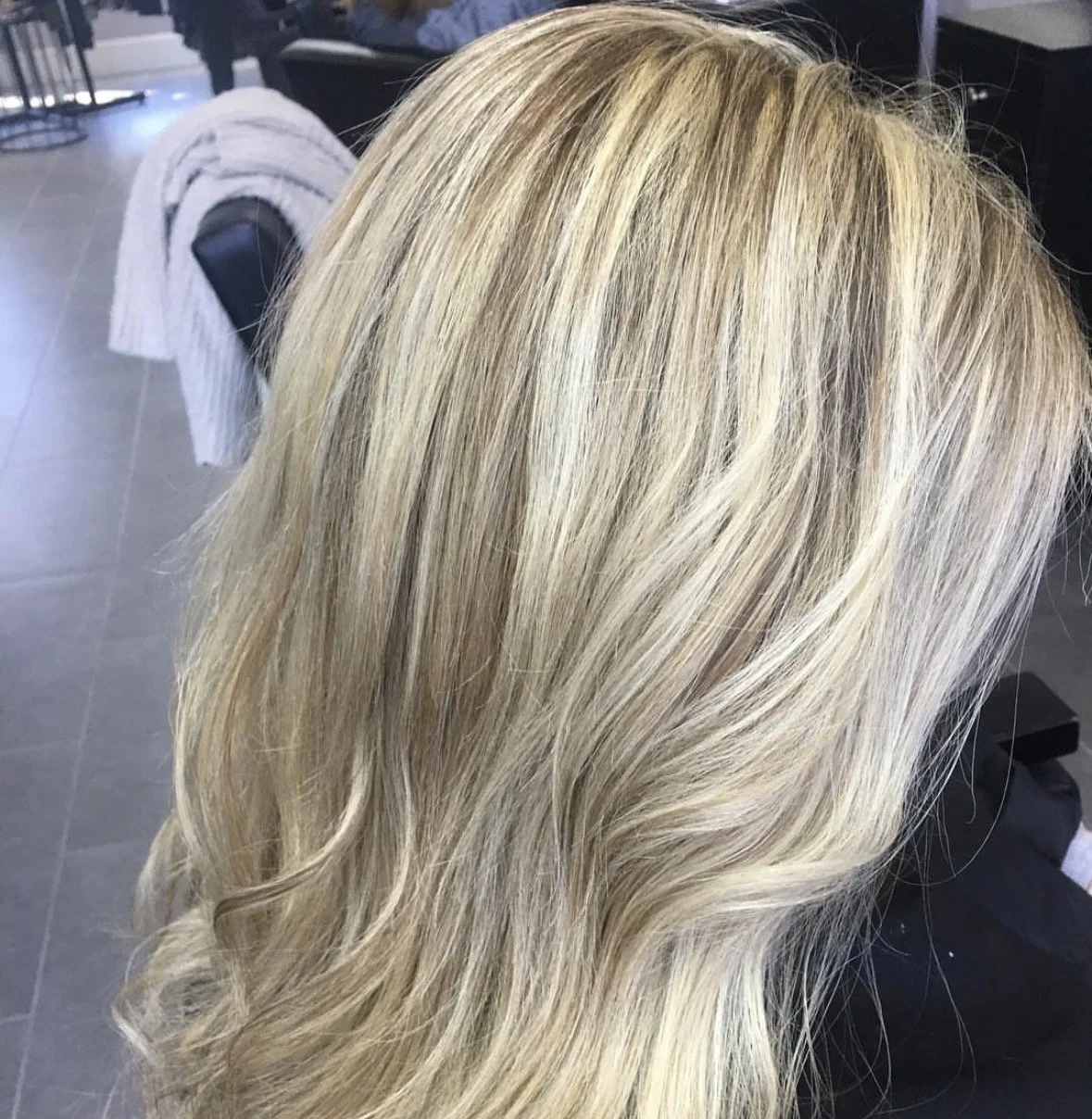 Blonde wavy hair in a salon setting.
