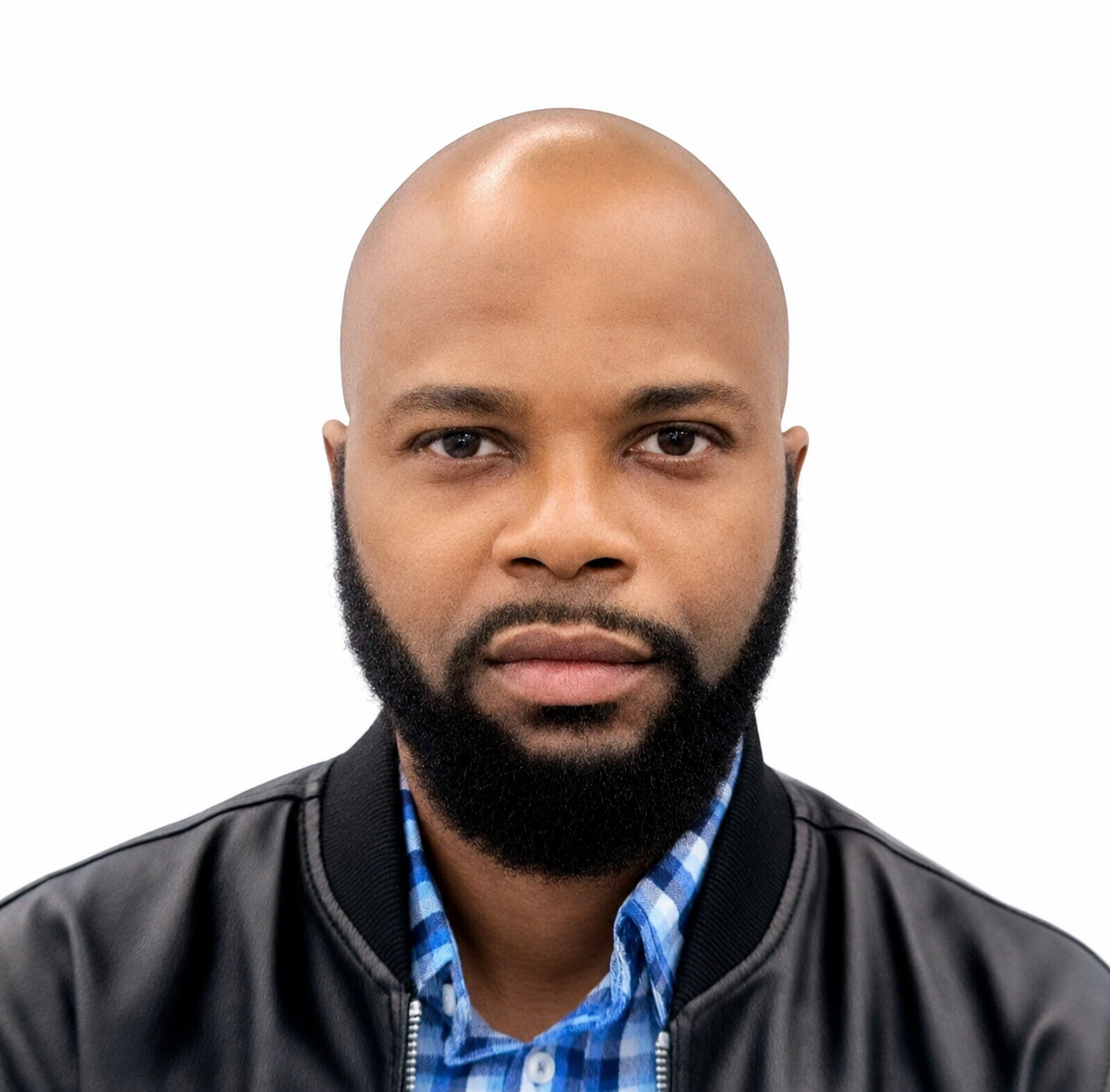 Portrait of a man with a bald head and full beard, wearing a black leather jacket and blue checkered shirt, against a white background.