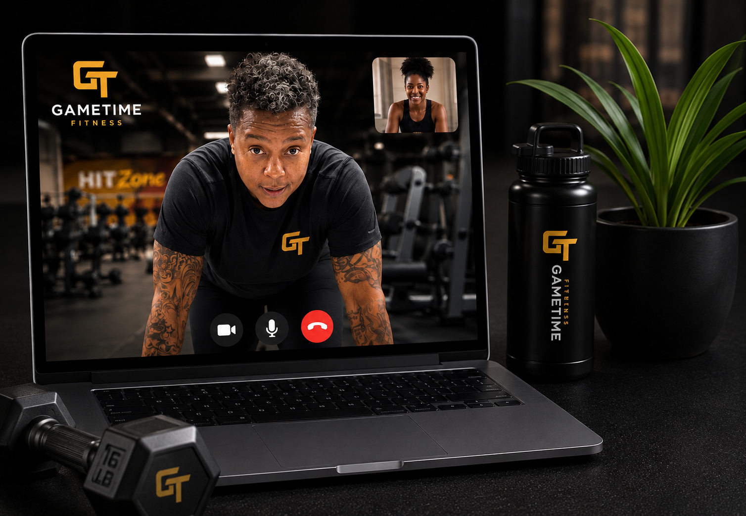 A laptop on a table showing a video call with a man and woman, a black water bottle with the words 'Gametime Fitness,' a potted plant, a pair of dumbbells, and a gym background visible on the laptop screen.